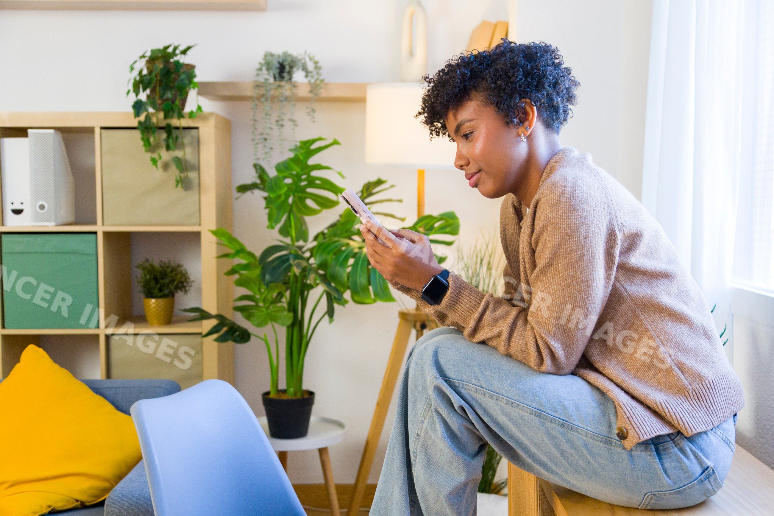 Young African American woman using smartphone indoors