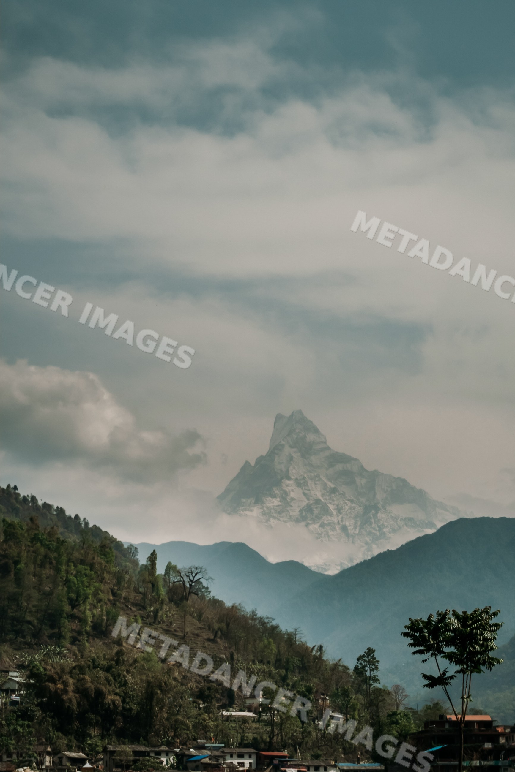 Mountain peak towering over forested hills and village landscape