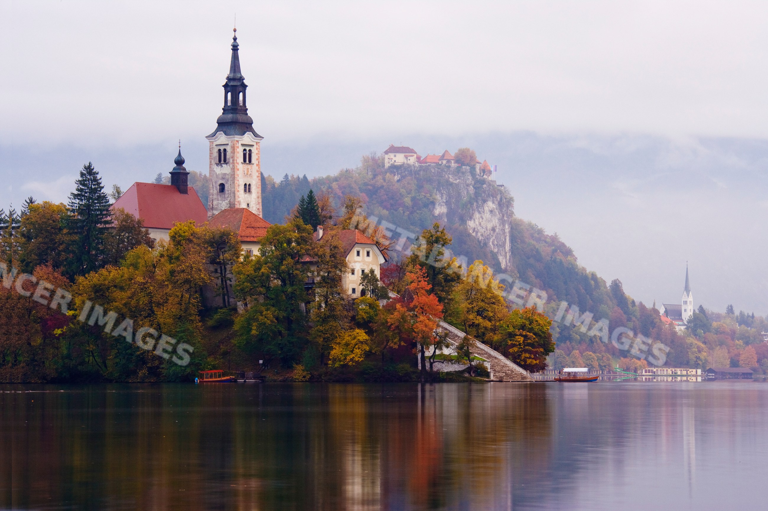 Church of assumption on lake bled island with autumn scenery