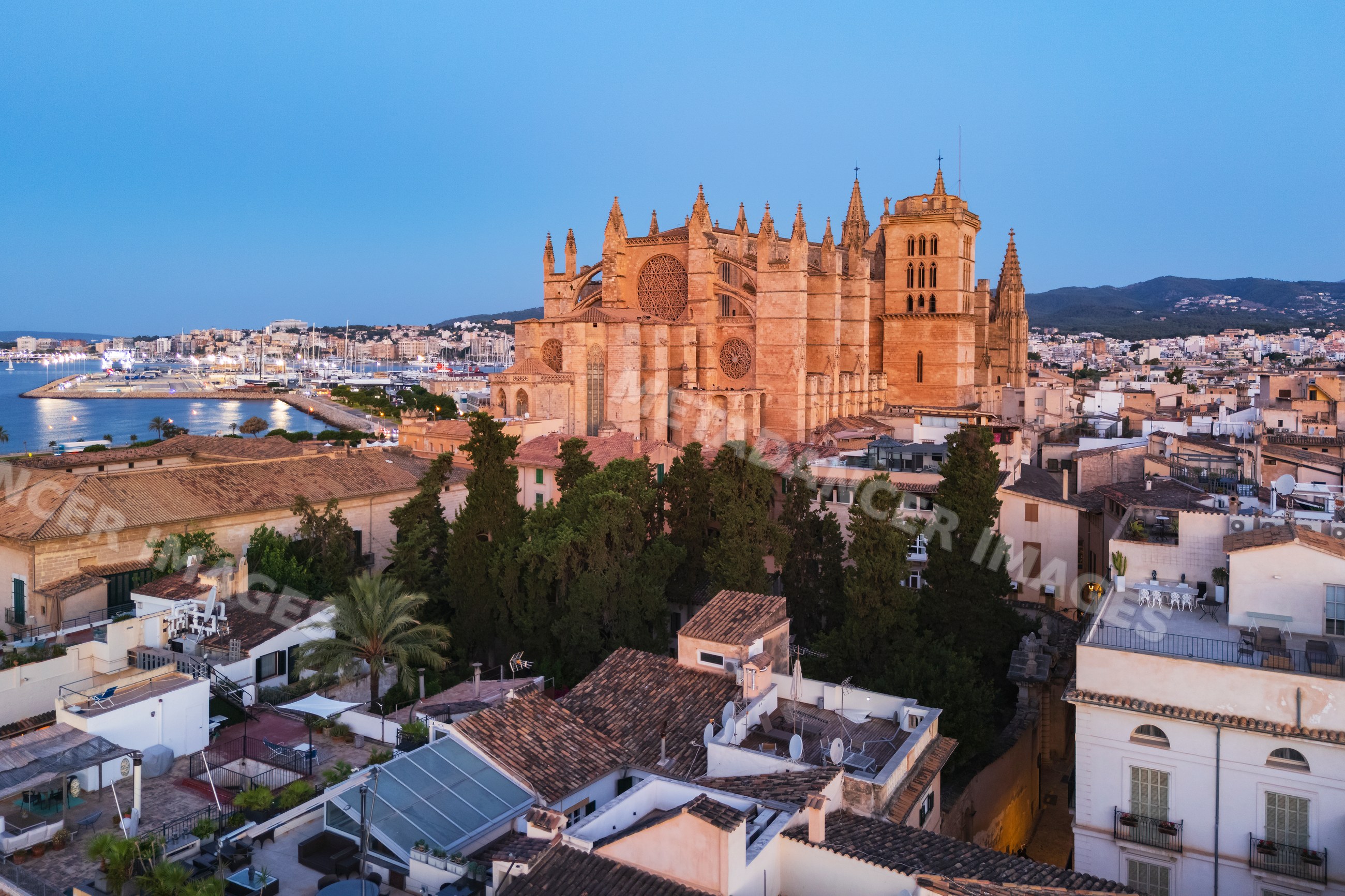 Cathedral in Palma de Mallorca with harbor and cityscape at dusk