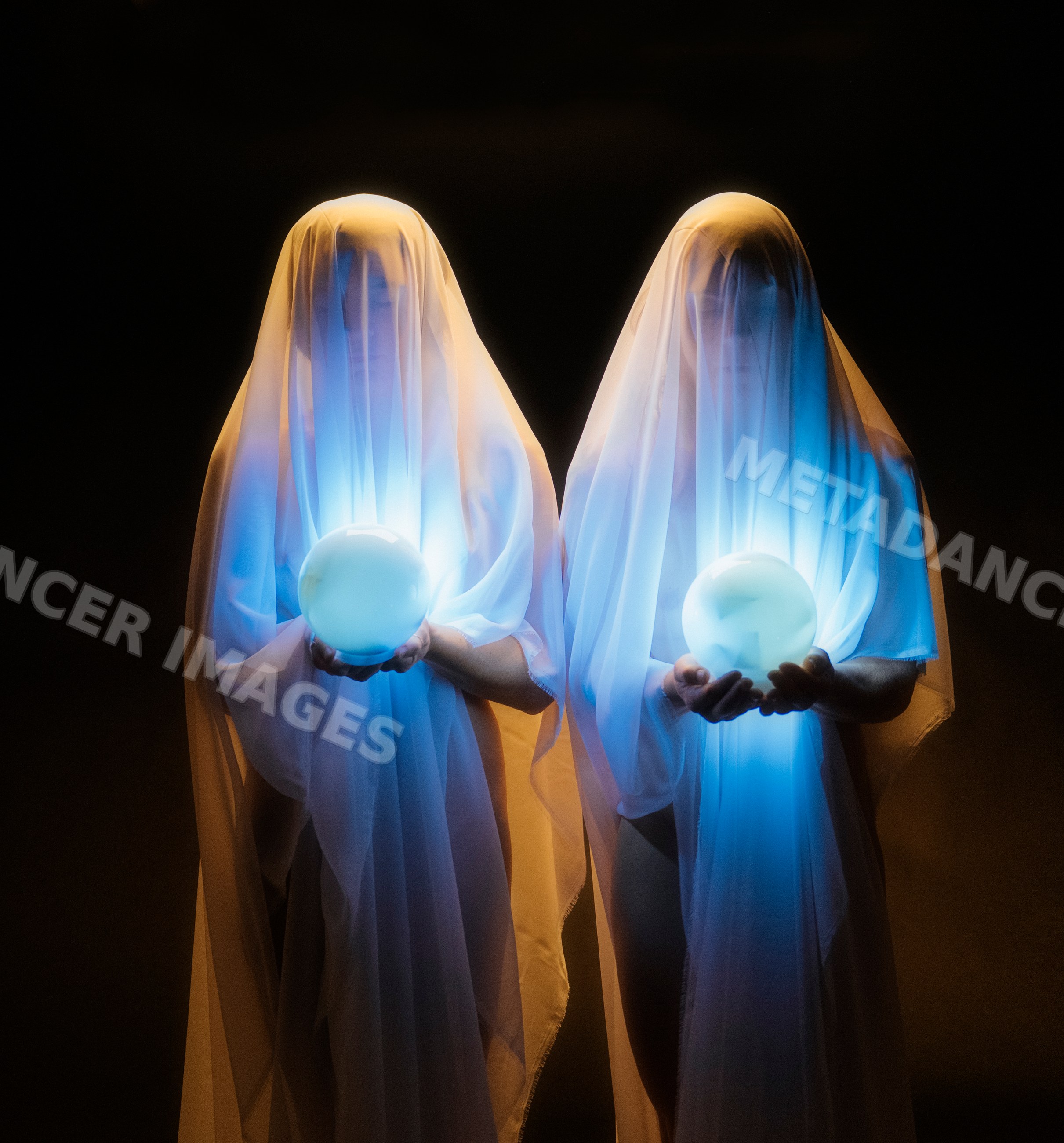 Two ghostly figures holding glowing orbs