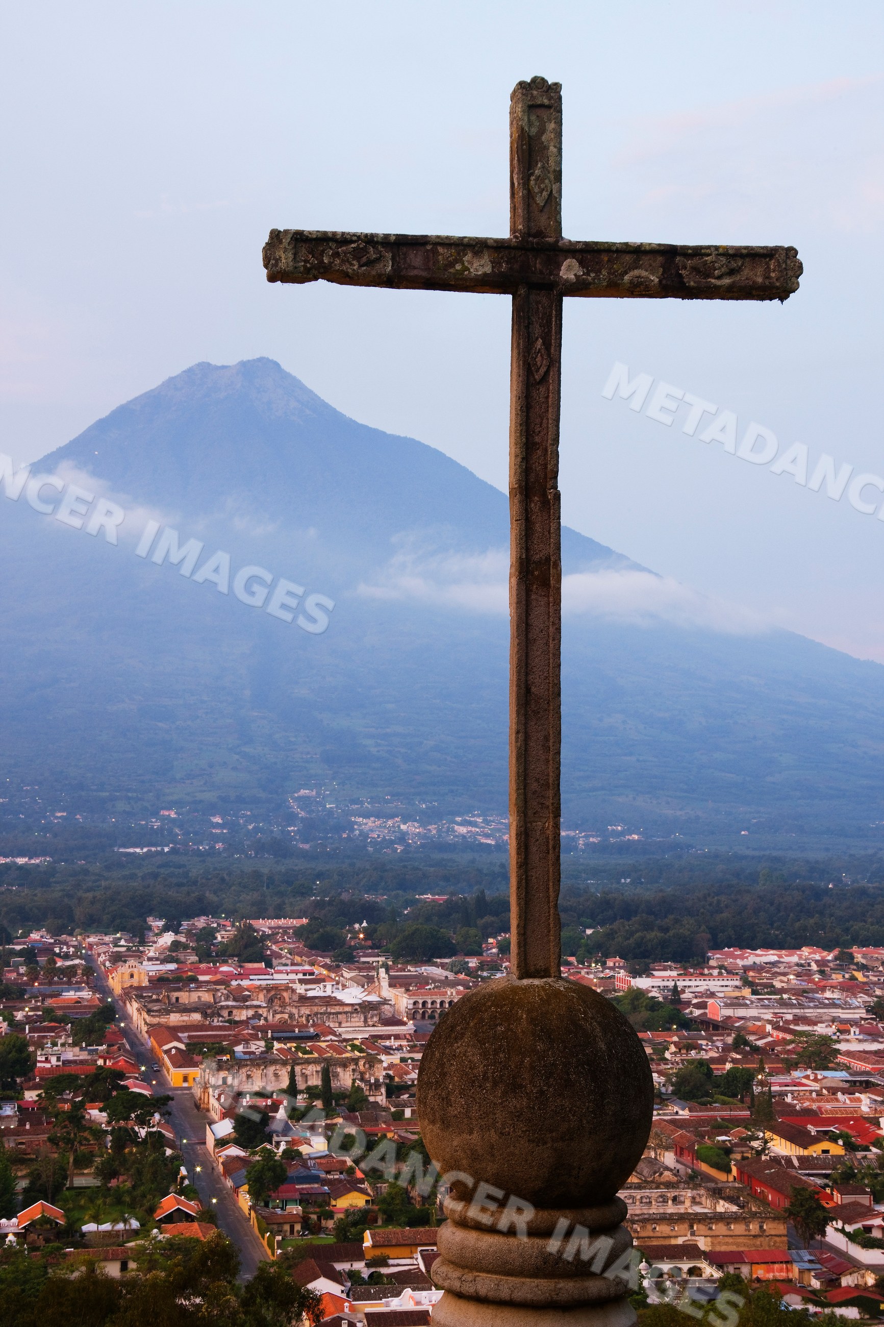 Stone cross overlooking antigua with volcan agua volcano