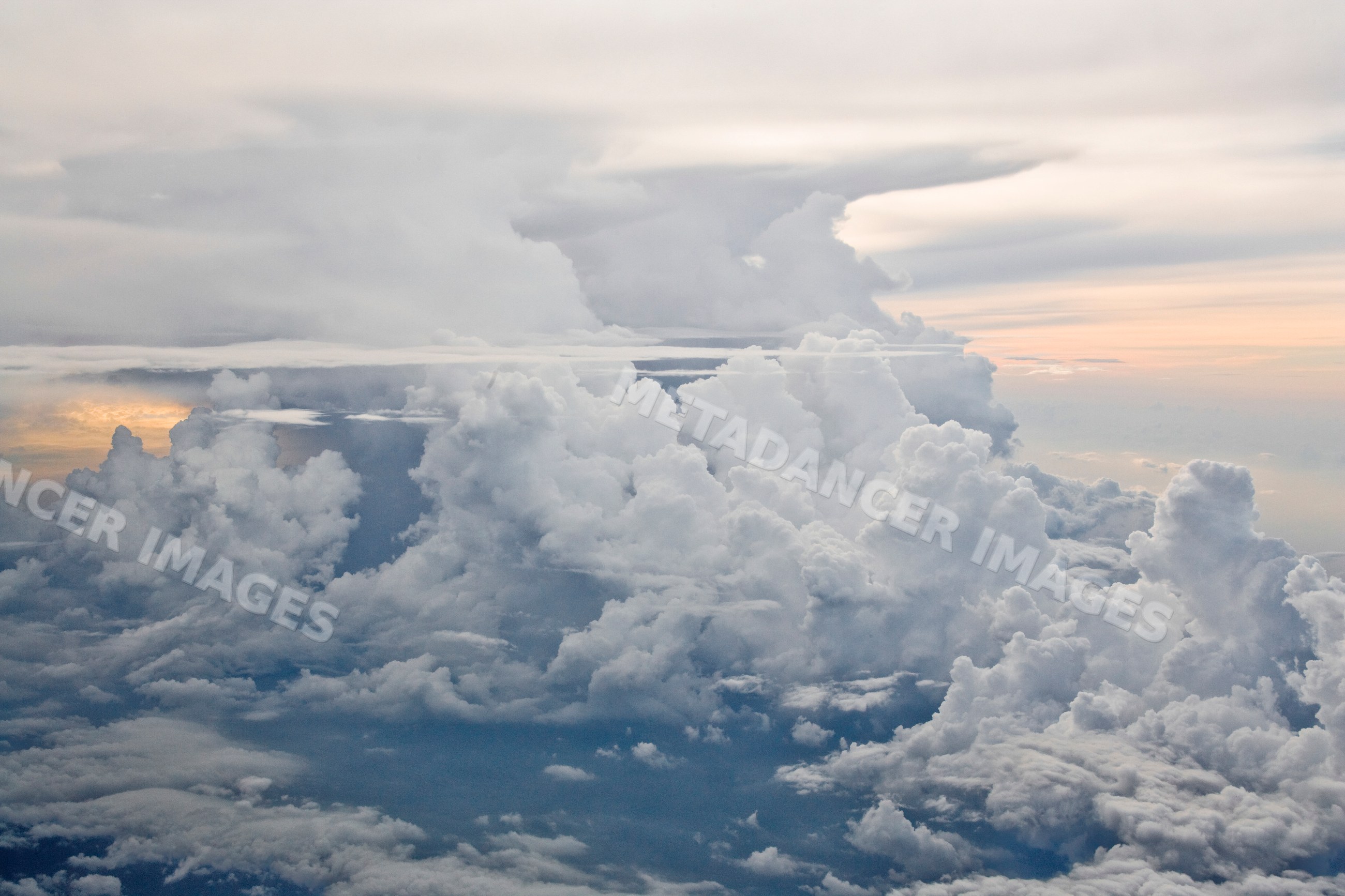 Cumulus clouds filling sky with warm sunset light