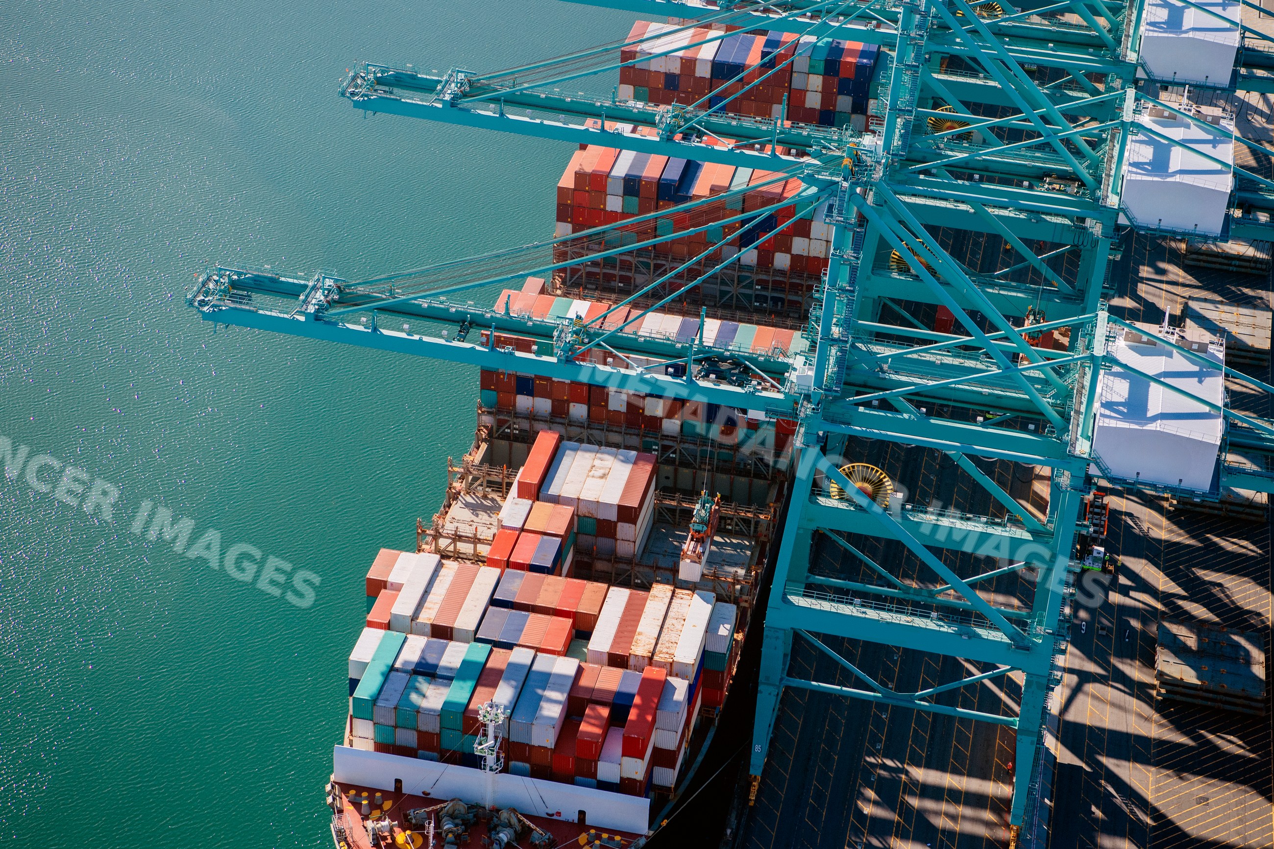 Container ship loading at port cranes in long beach, california