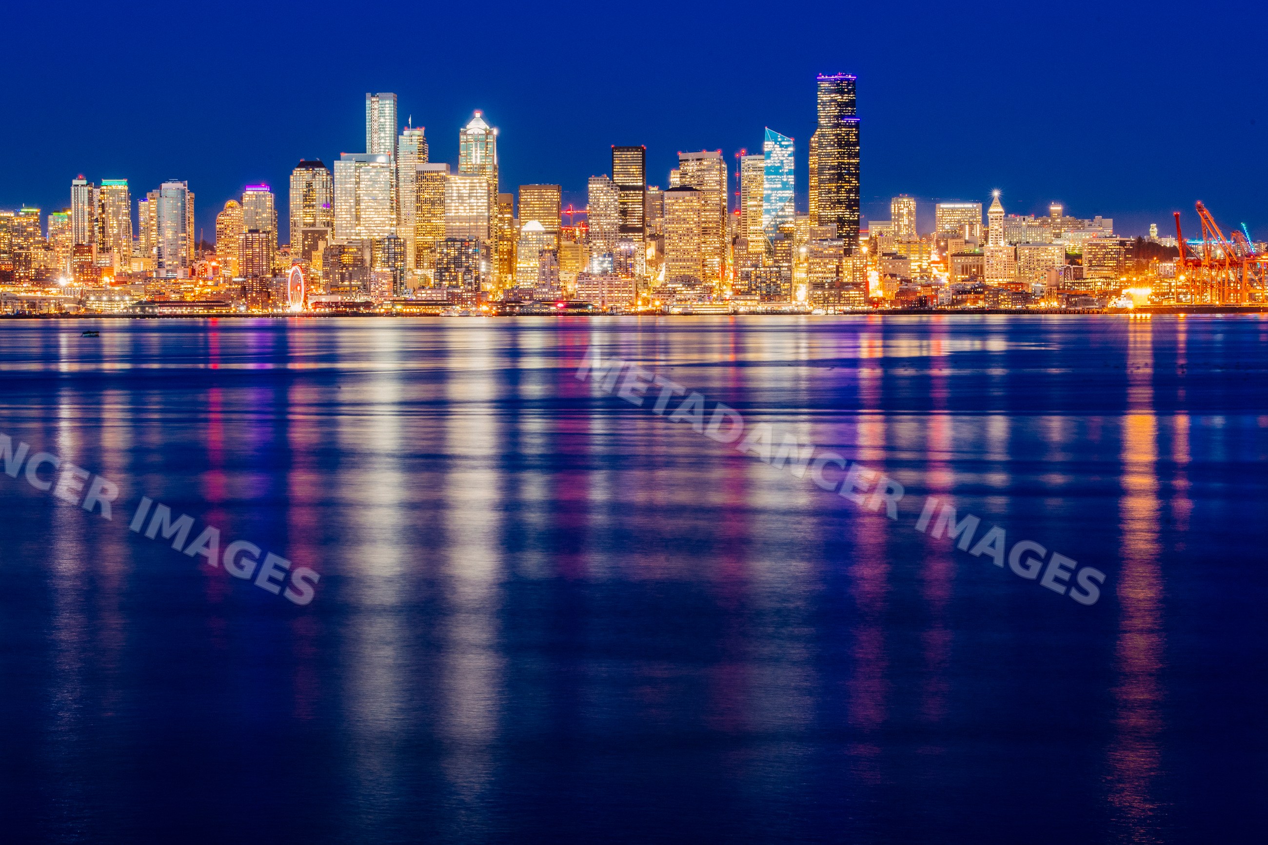 Seattle city skyline illuminated at night with water reflections