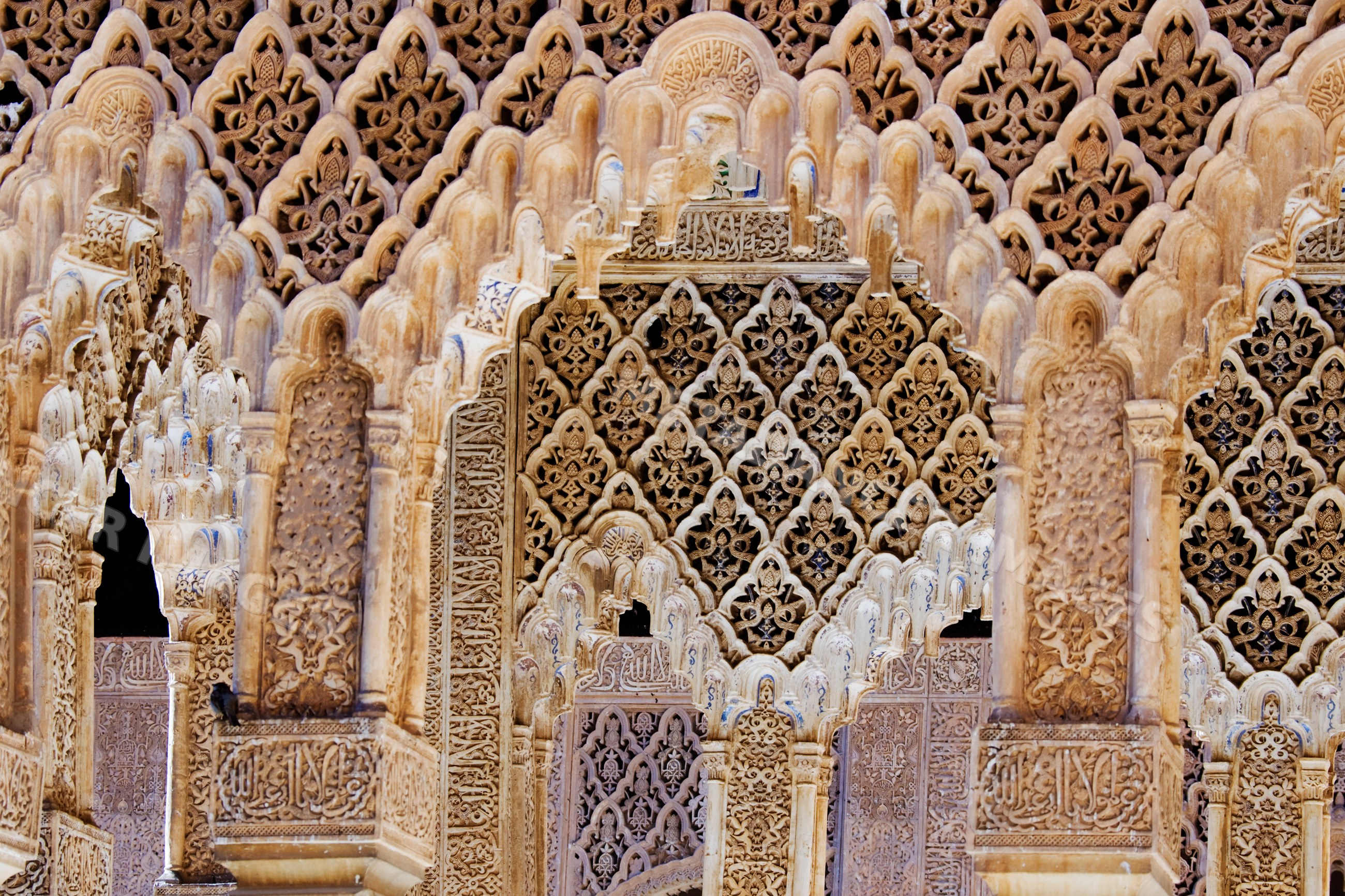 Carved stone arches with islamic patterns and arabic calligraphy