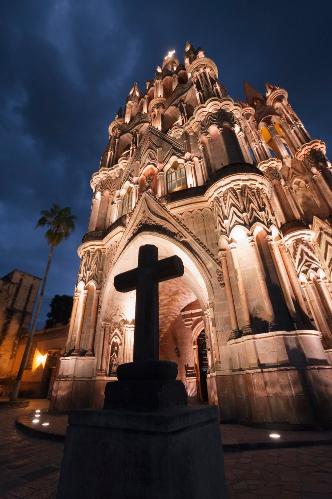 Illuminated gothic stone church with cross mexico