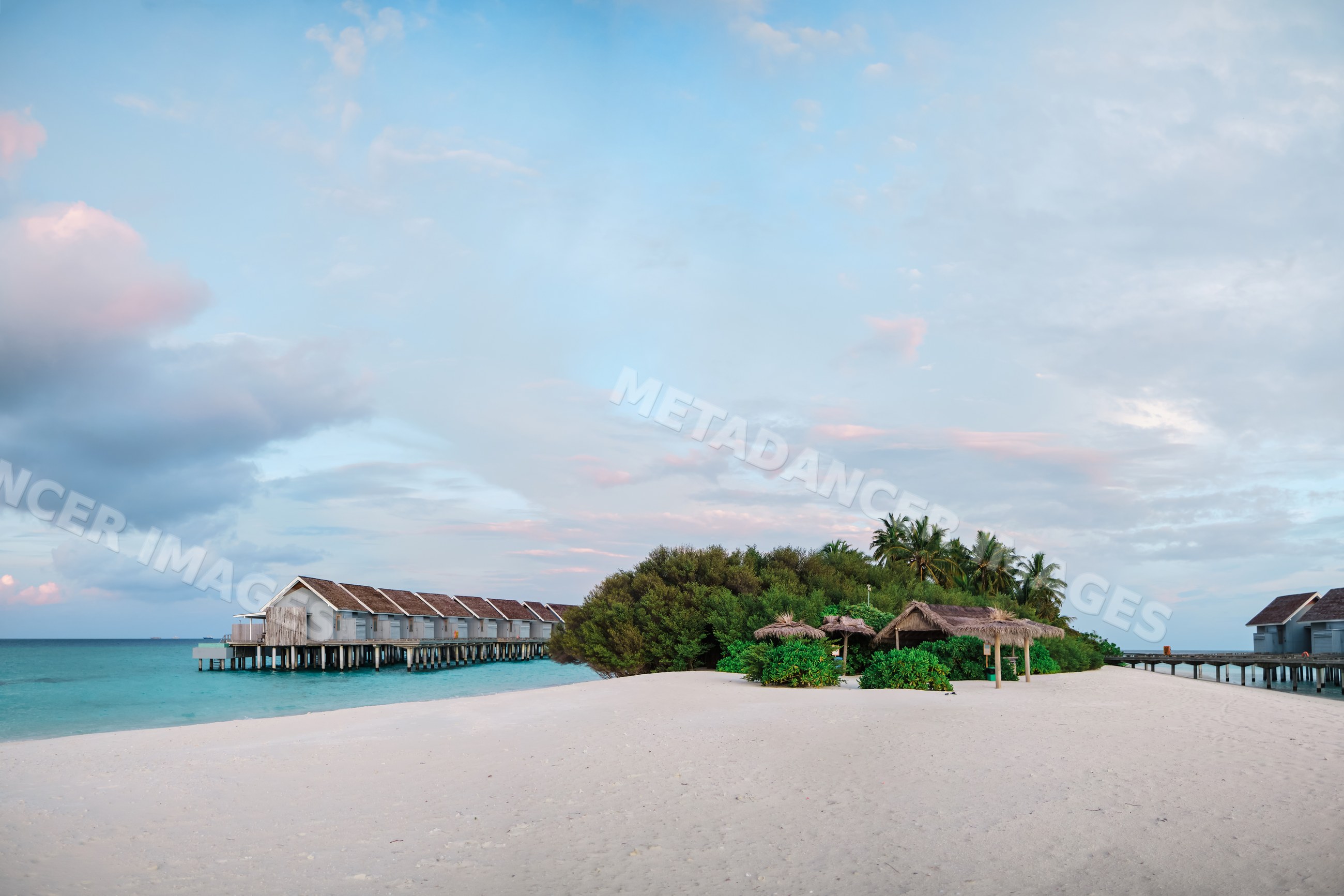 Tropical beach with overwater bungalows and palm trees in a beach