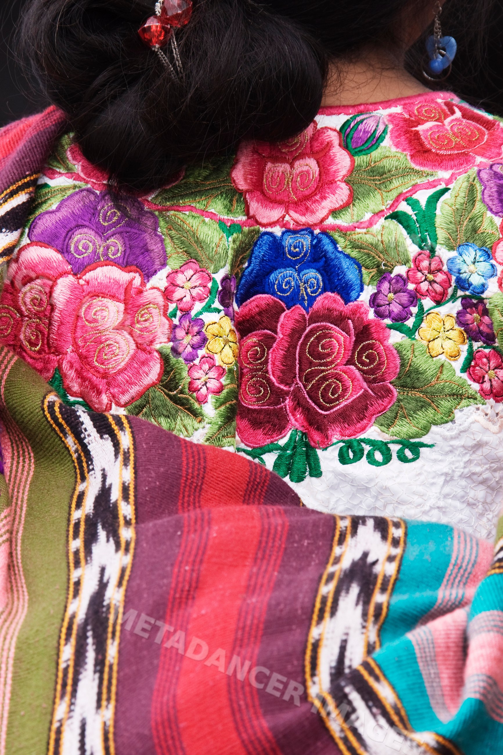 Woman wearing an embroidered blouse and a colorful shawl, guatemala
