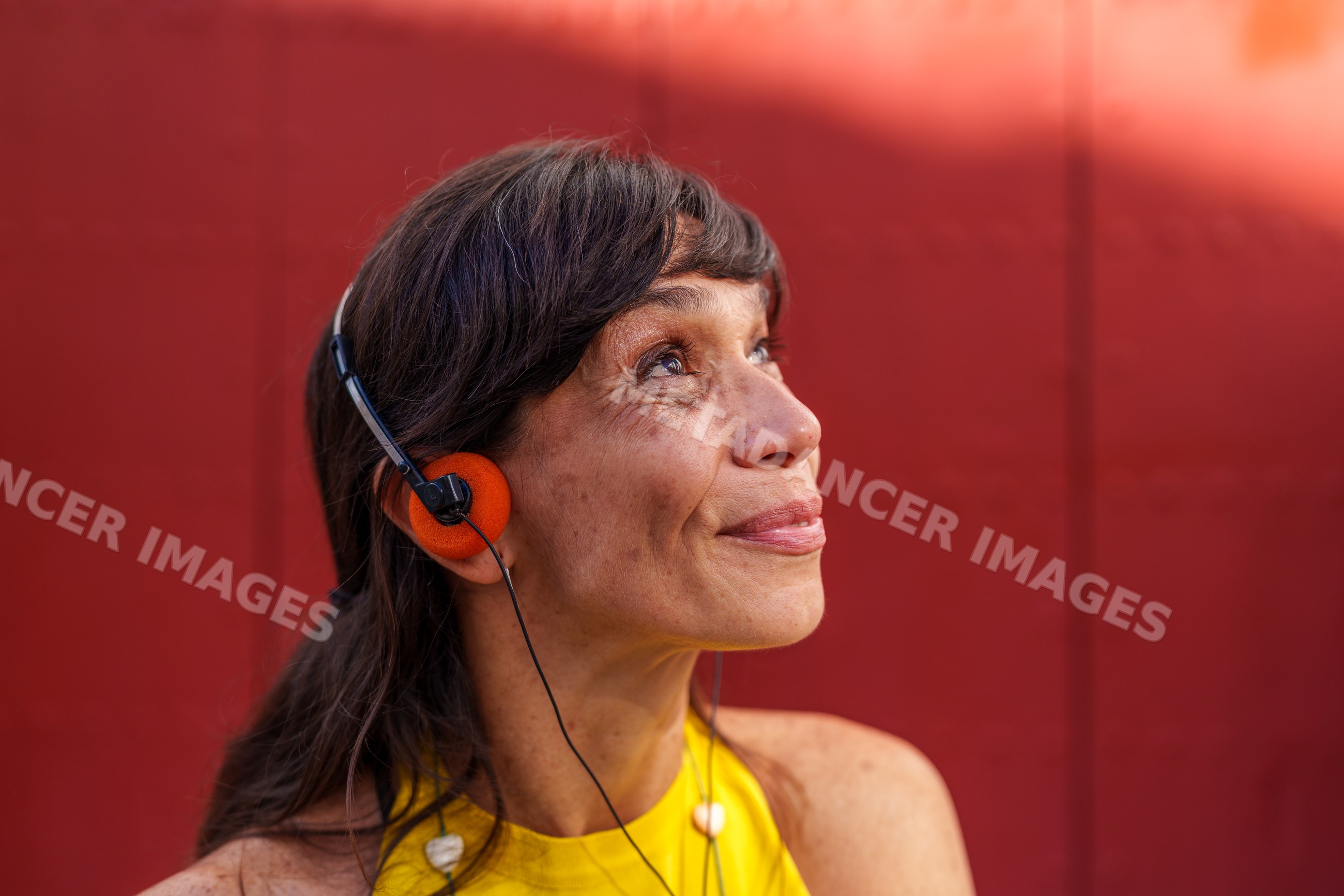 Mature Hispanic woman listening to music outdoors