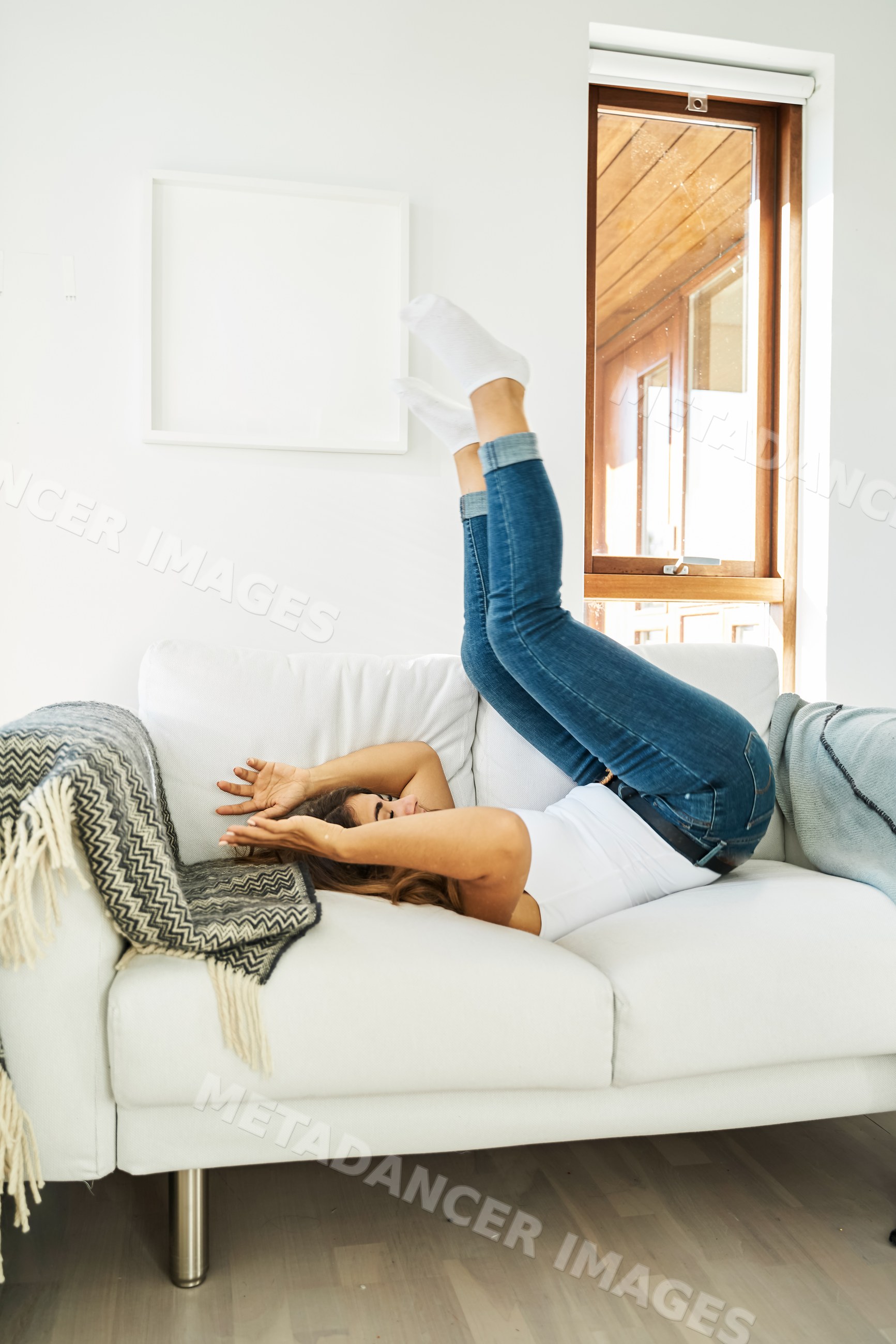 Woman relaxing with legs up on a white couch