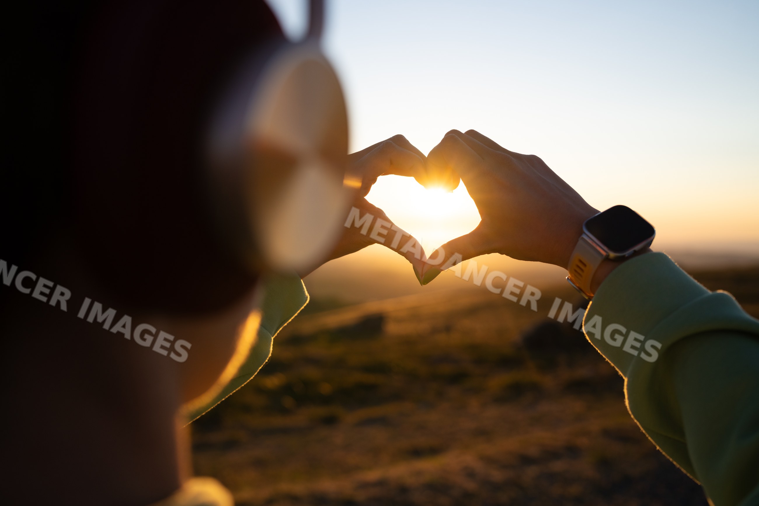 White Person forming heart shape with hands at sunset in Galicia Spain