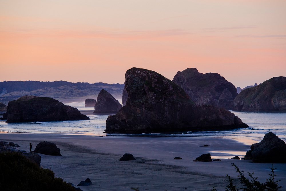 Rock formations along coastal beach at sunset in Oregon