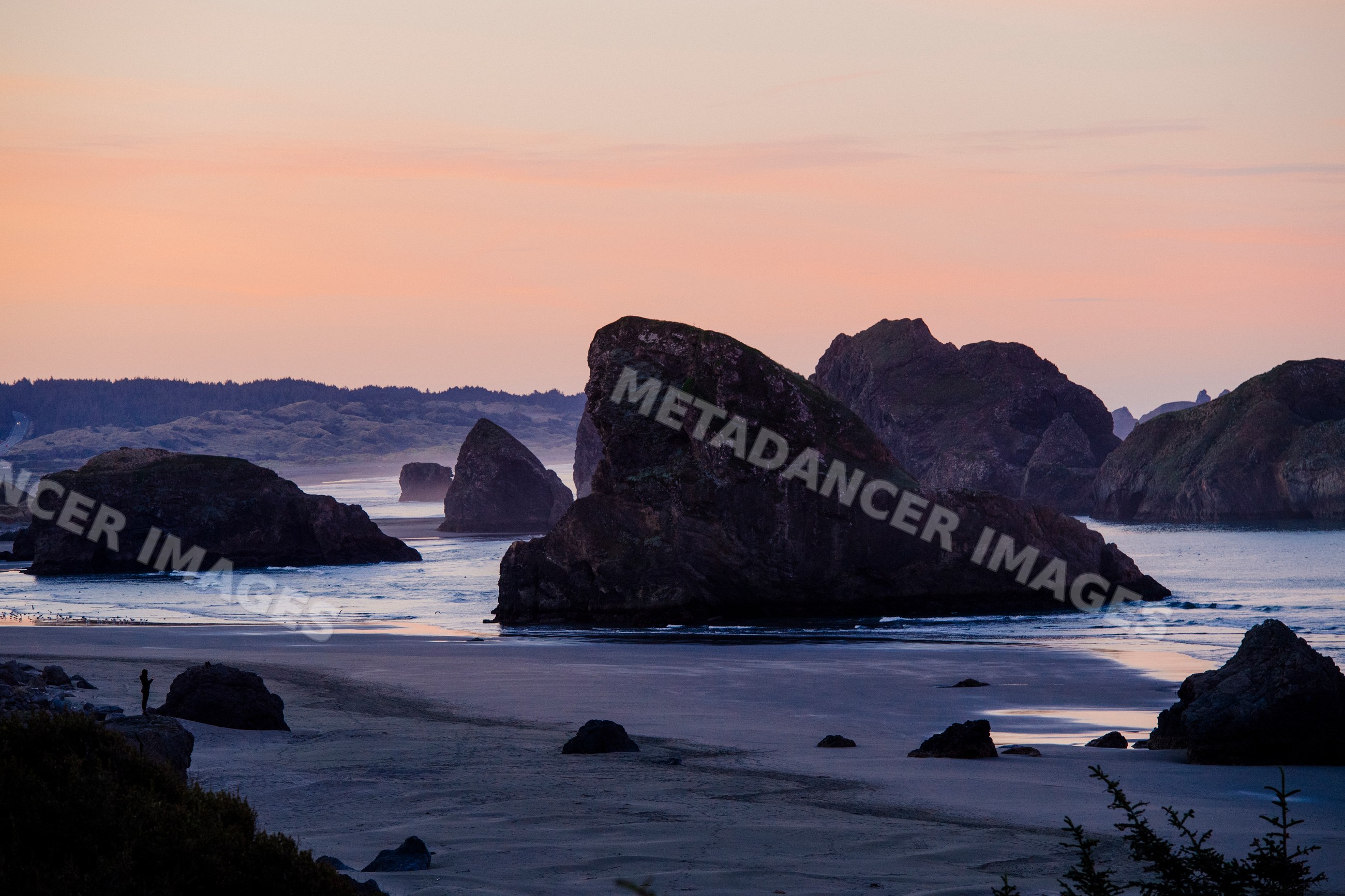 Rock formations along coastal beach at sunset in Oregon