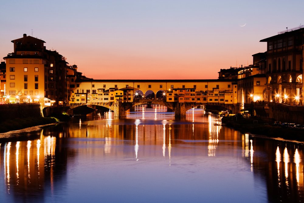 Ponte vecchio bridge over arno river at sunset italy