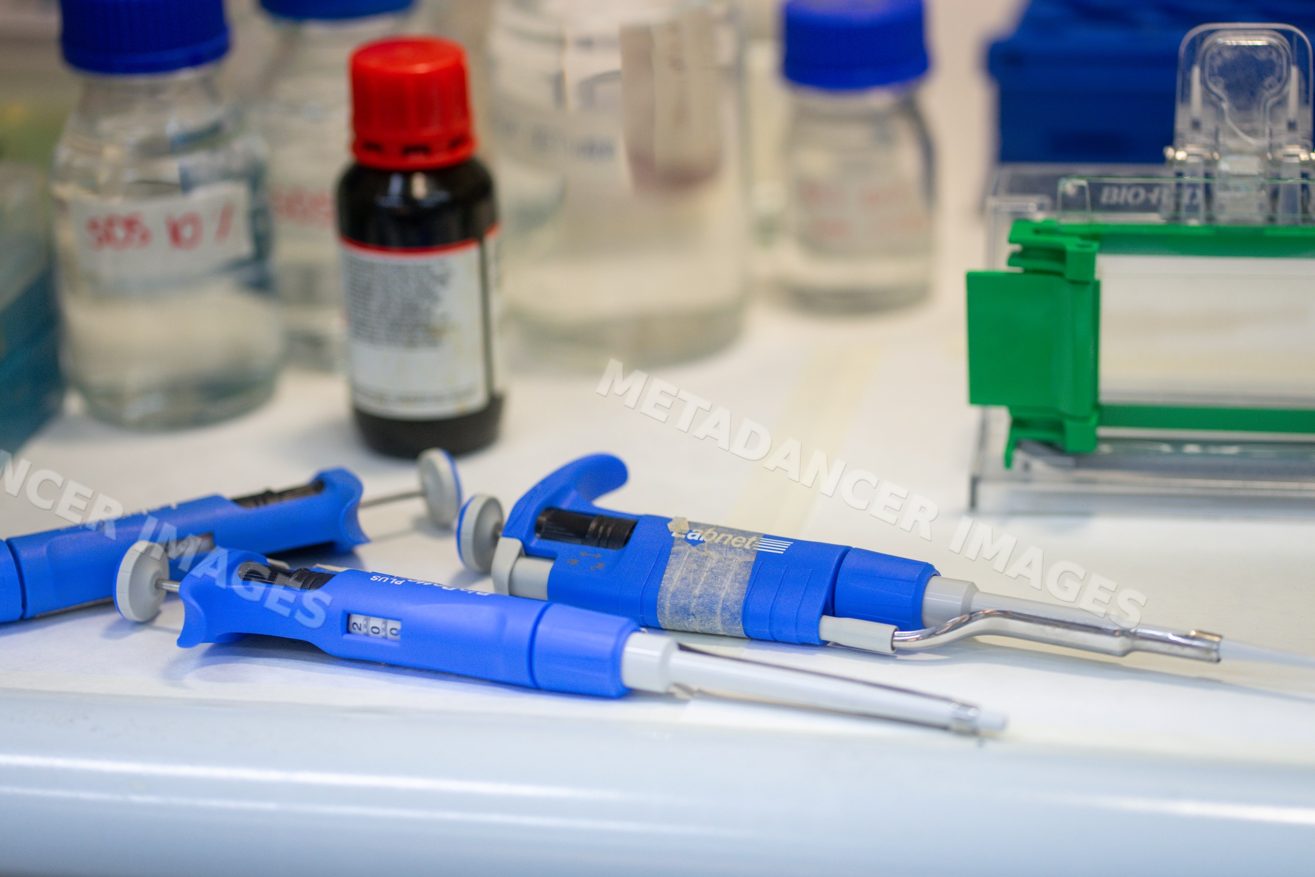 Laboratory pipettes and bottles on laboratory bench in Seville