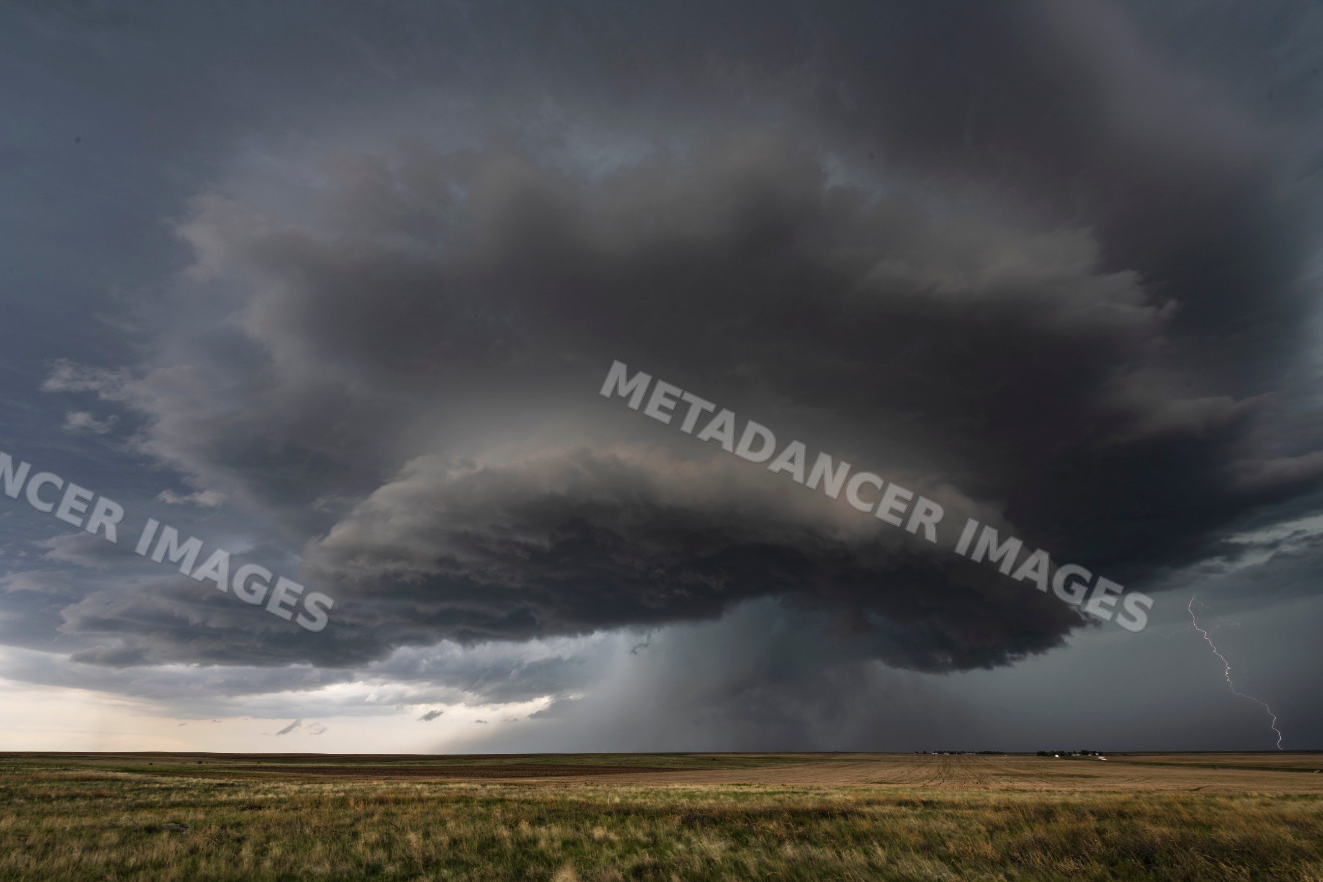 Supercell storm with lightning over grassland in merino, colorado