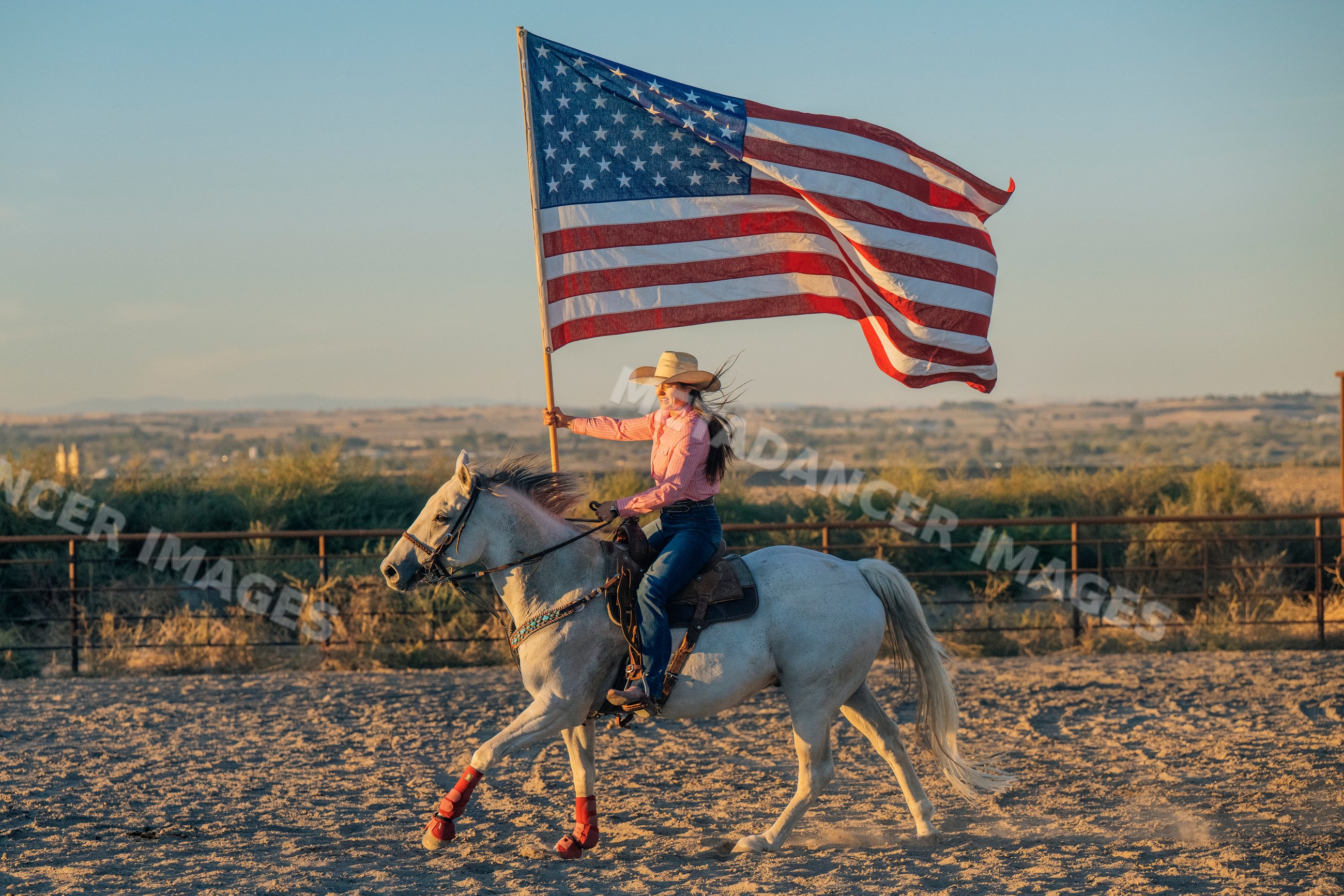 White woman riding horseback holding american flag
