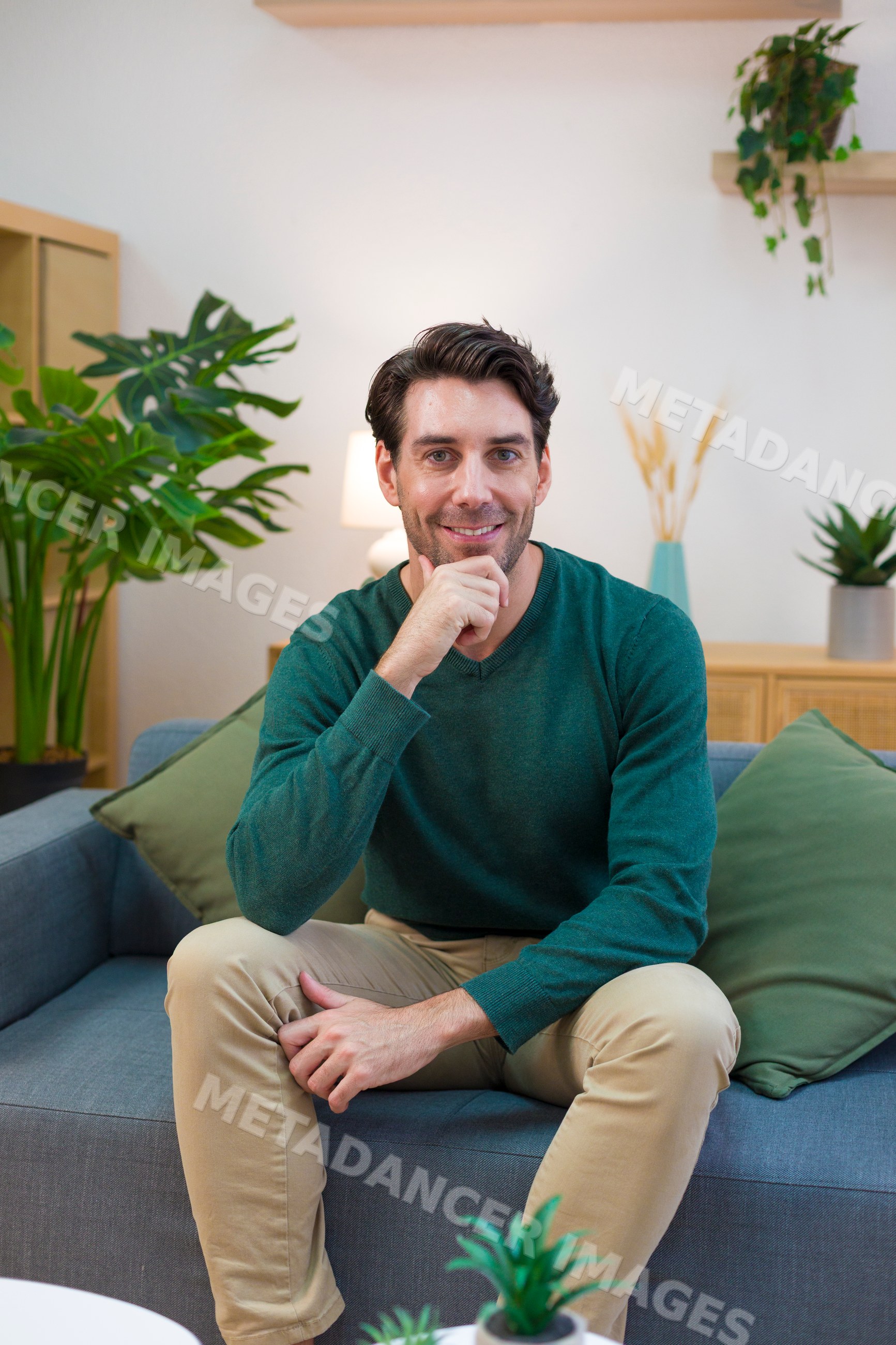 White man sitting relaxed on sofa in modern living room