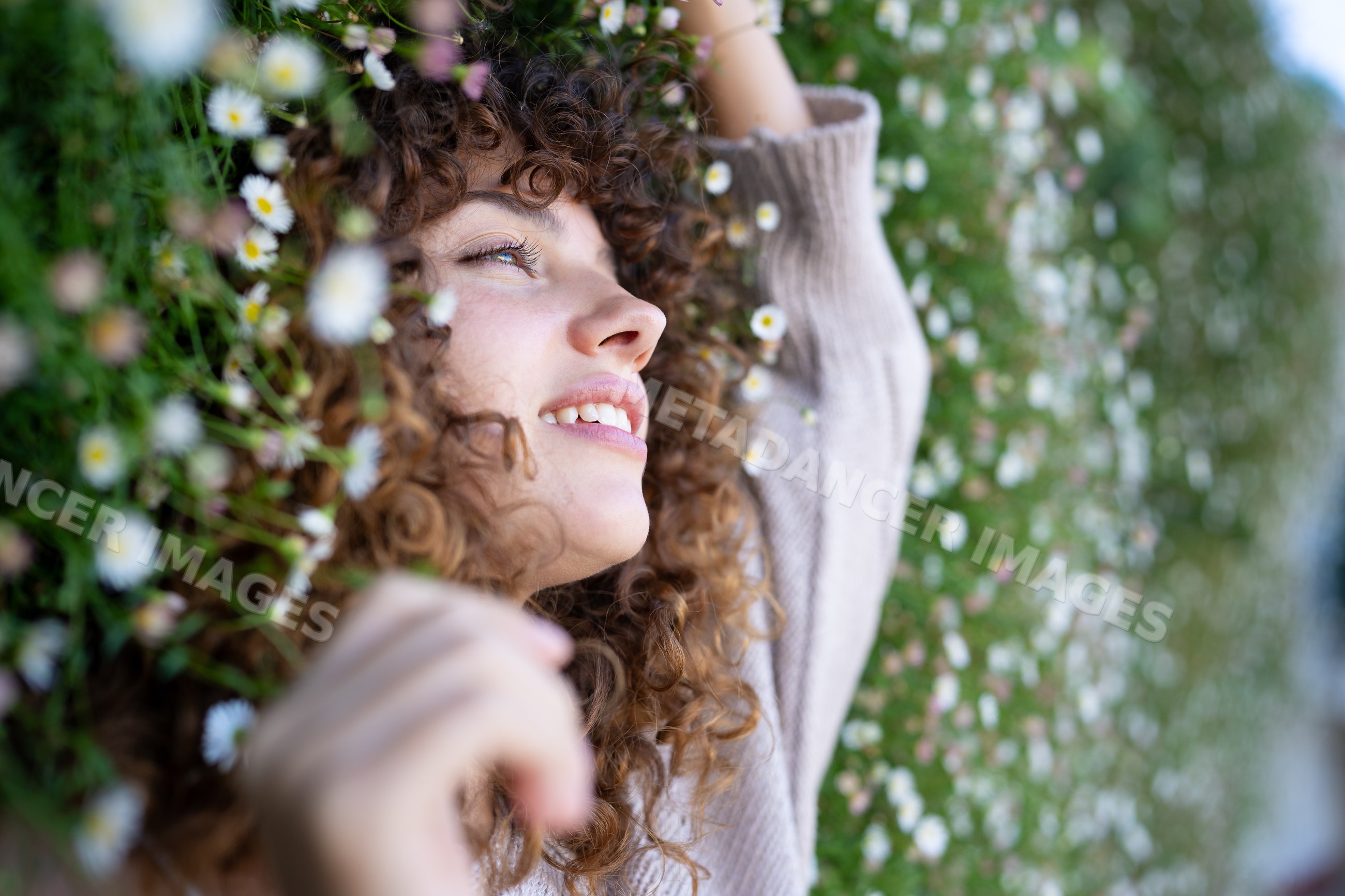 White woman with curly hair lies smiling
