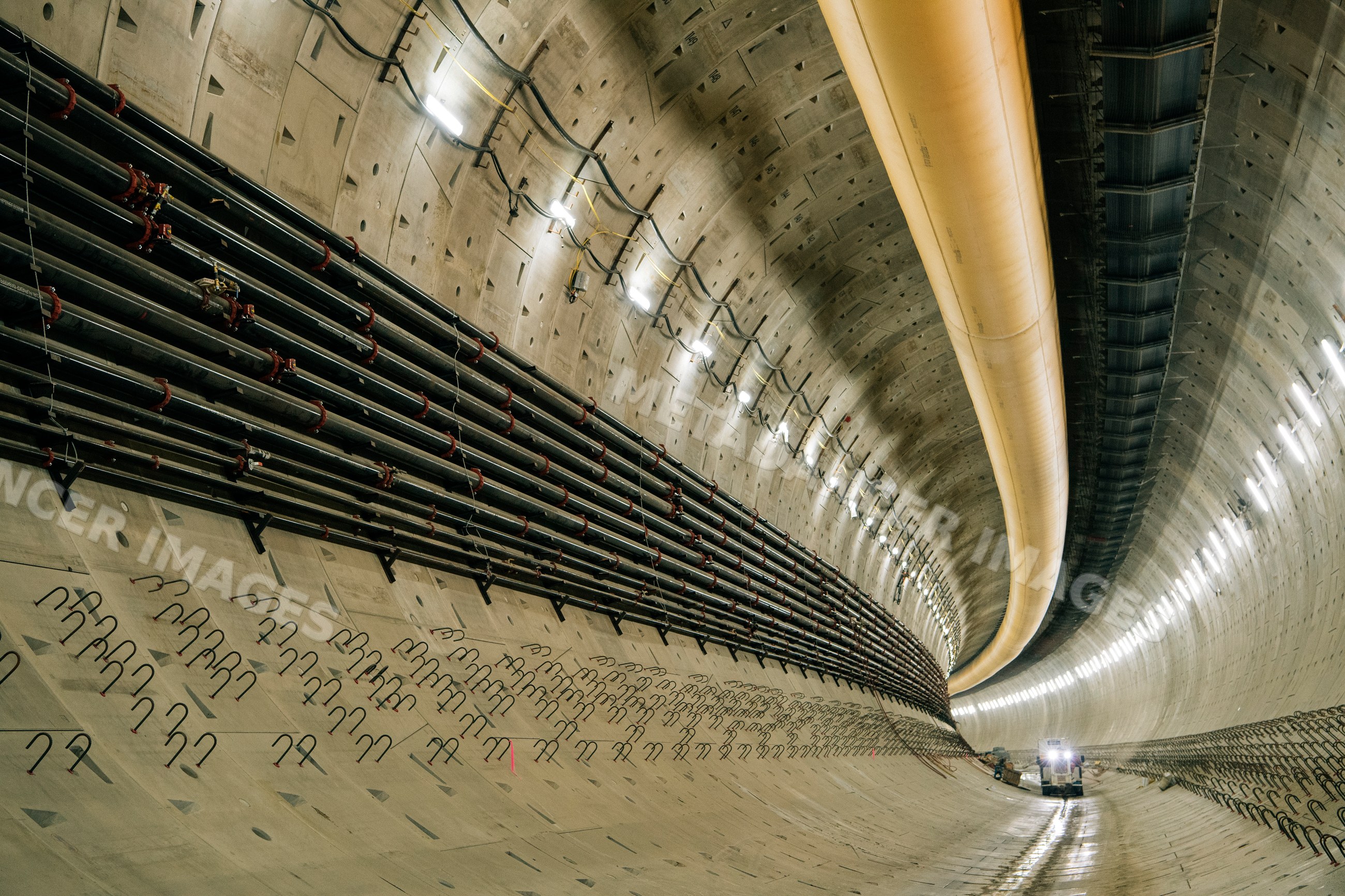 Interior of a tunnel under construction with utility pipes