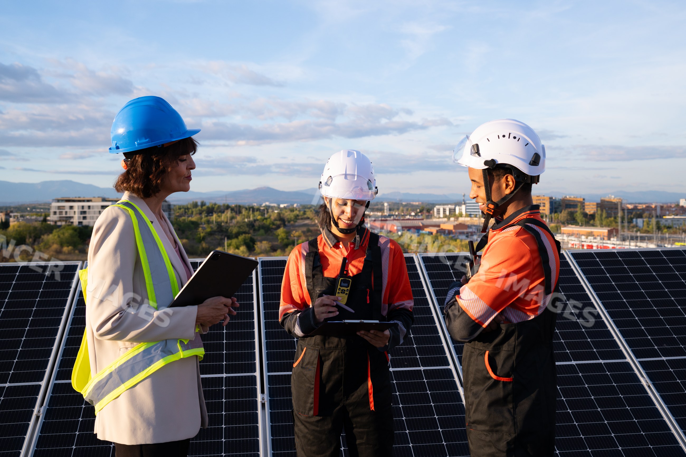 Engineers and Hispanic and white workers inspecting solar panels