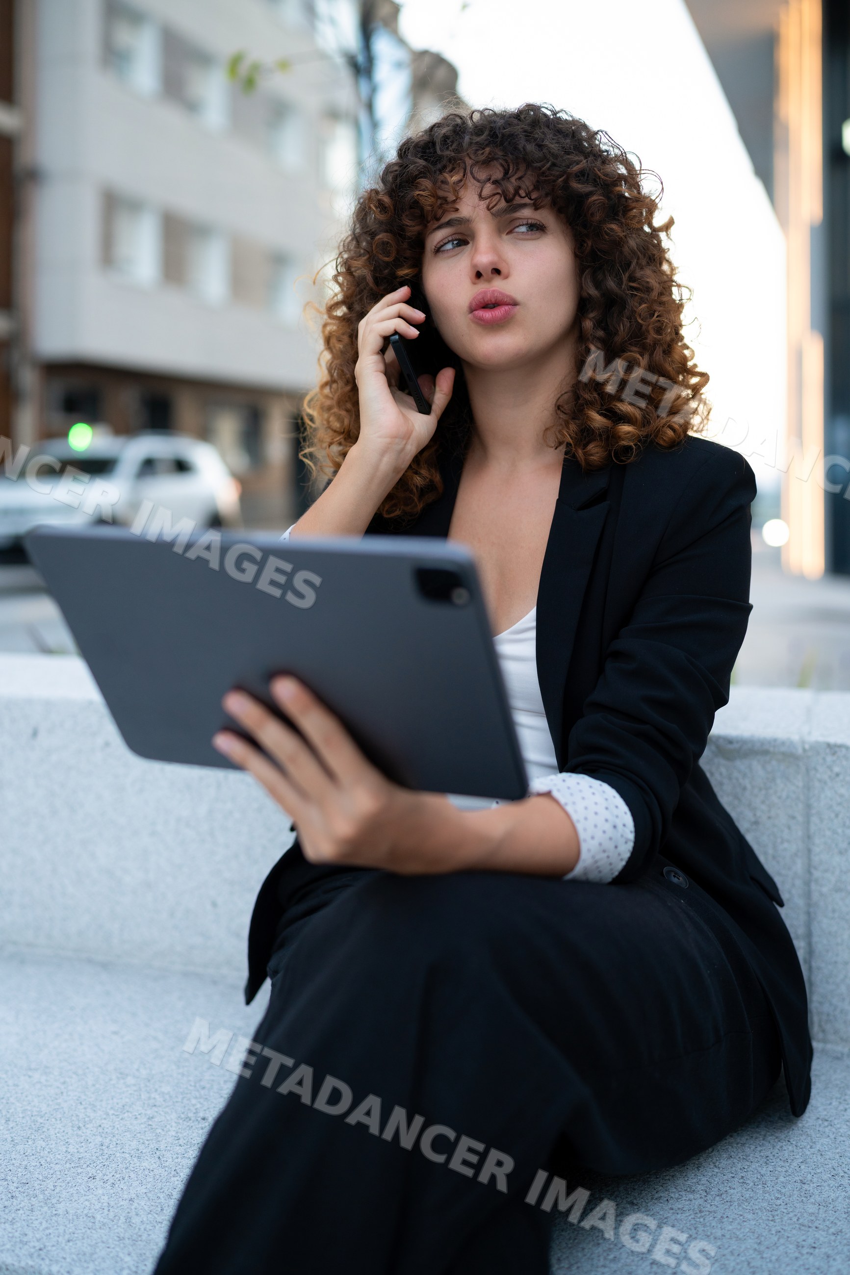 Business white woman using tablet and talking on phone outdoors
