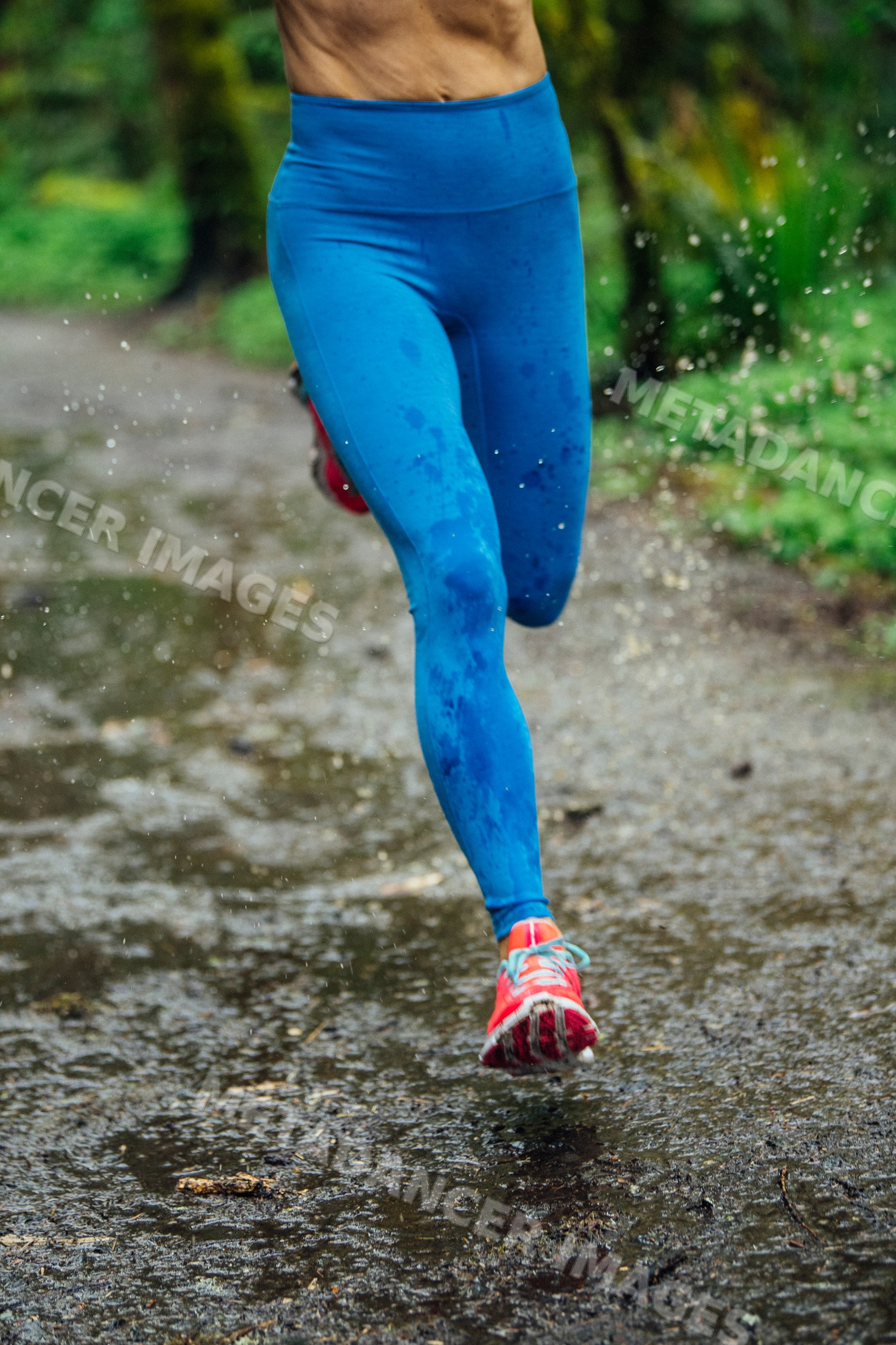 White runner splashing water on wet outdoor trail