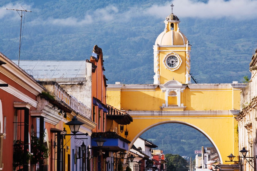 Clock tower and historic yellow arch guatemala street scene