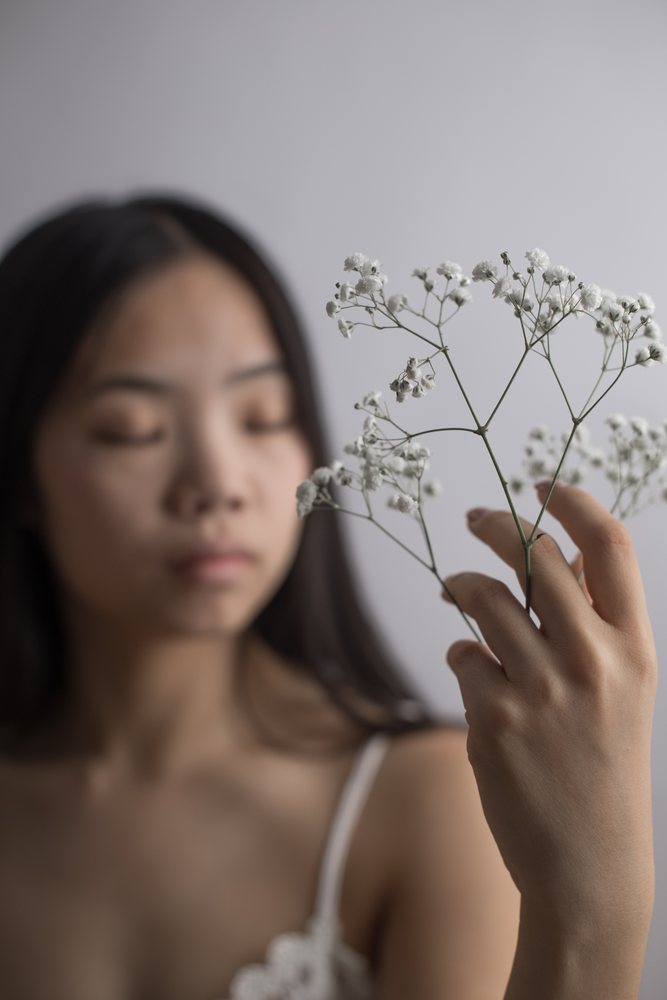 Young Southeast Asian woman holding delicate white baby's breath