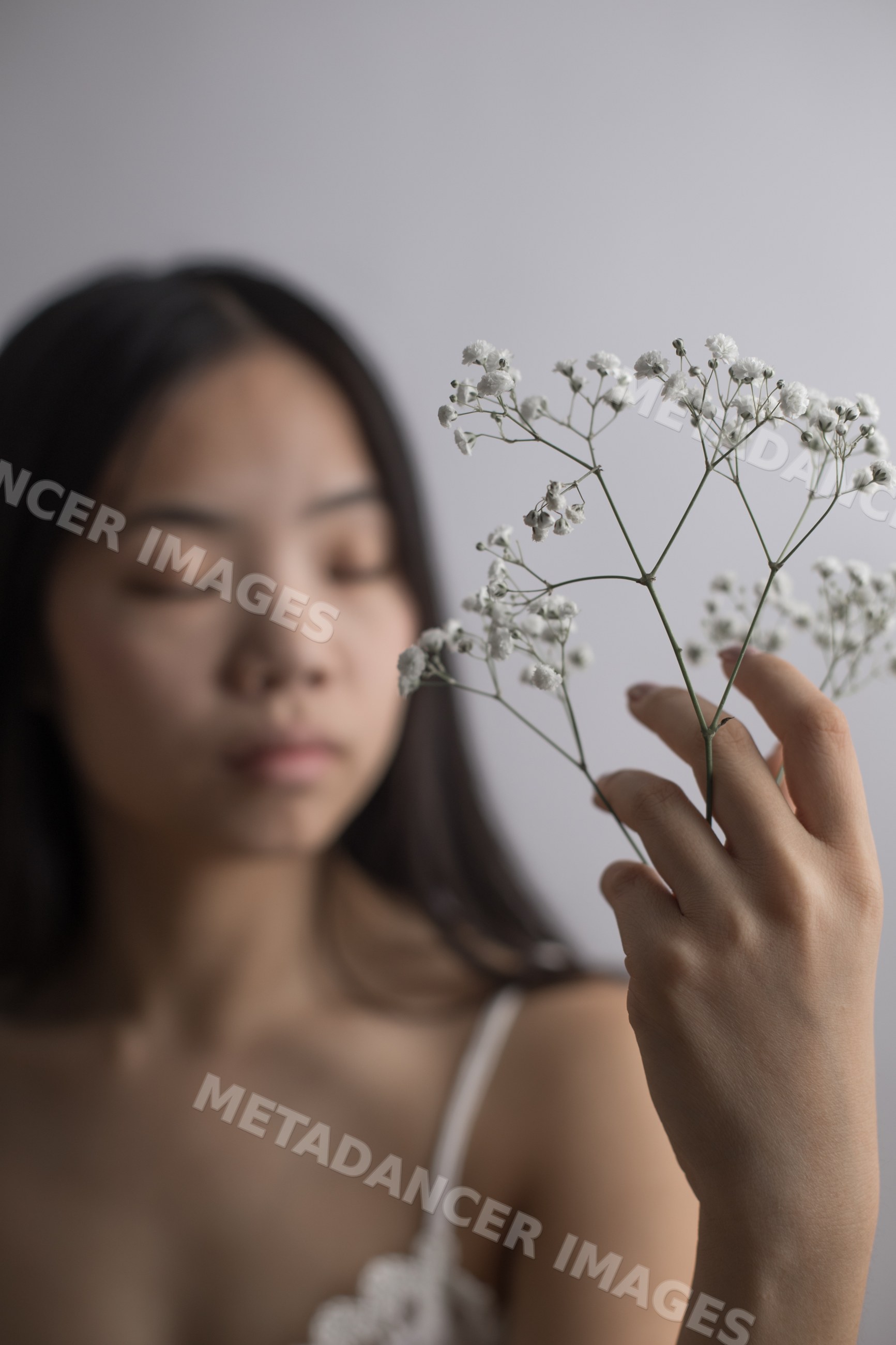 Young Southeast Asian woman holding delicate white baby's breath