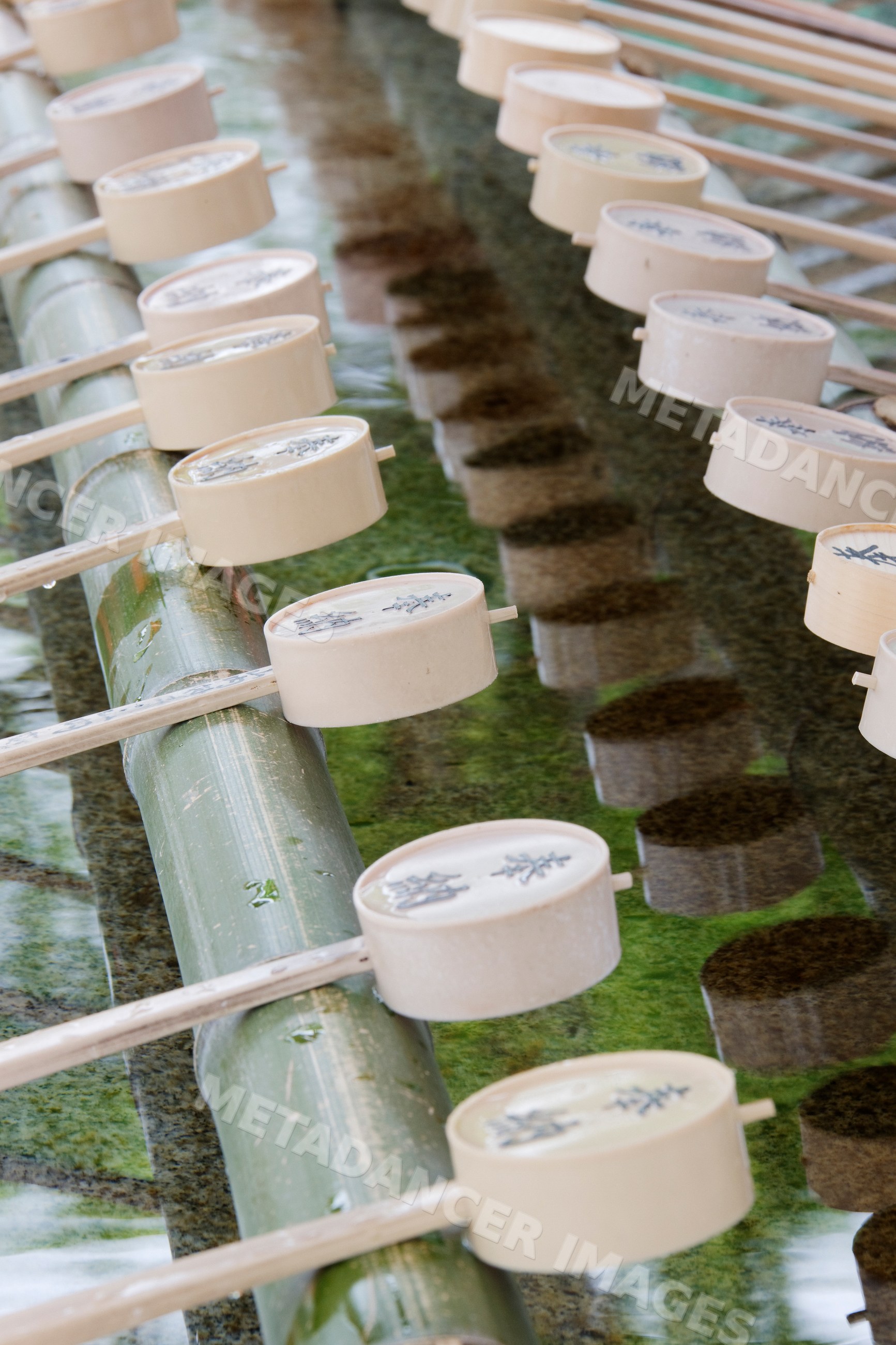 Wooden ladles over water basin at fushimi inari shrine in kyoto japan
