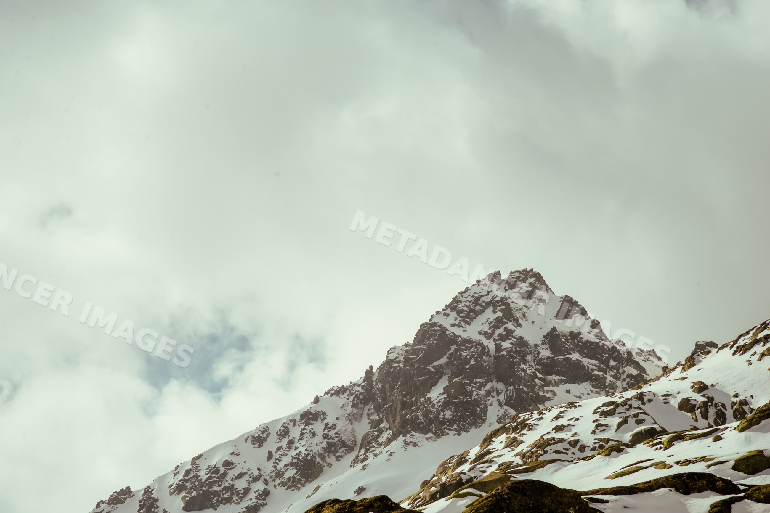 Snow-covered rocky mountain peak in Spain with overcast sky