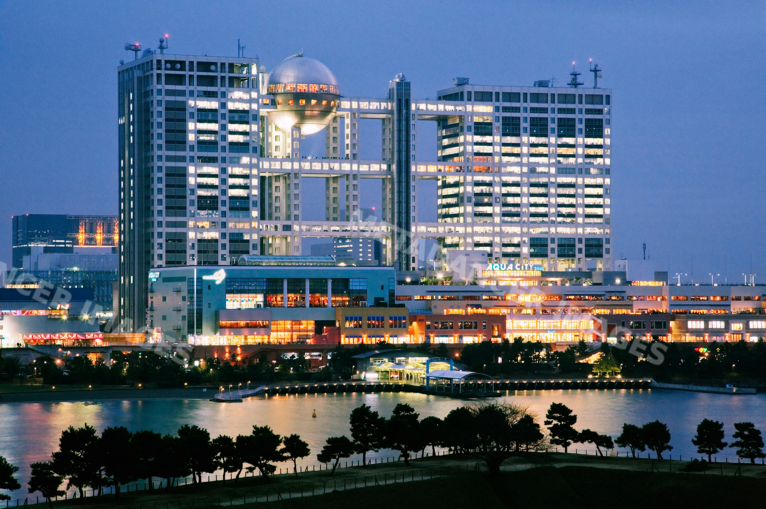 Aqua city and fuji tv building illuminated at night in odaiba tokyo
