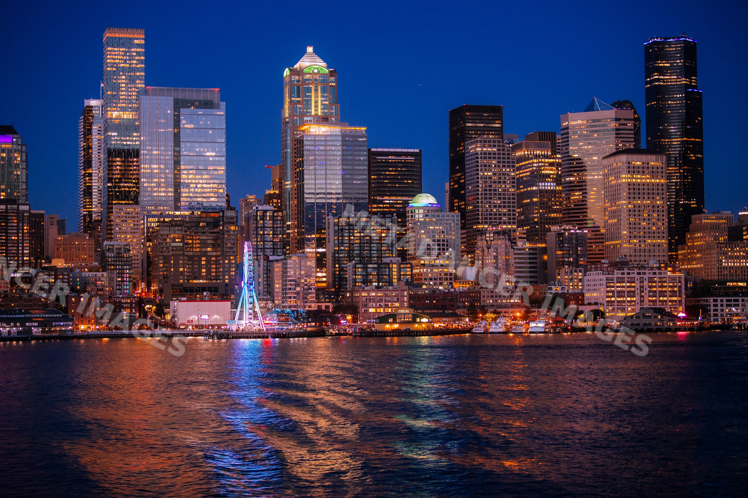 Seattle skyline illuminated at night reflecting on waterfront