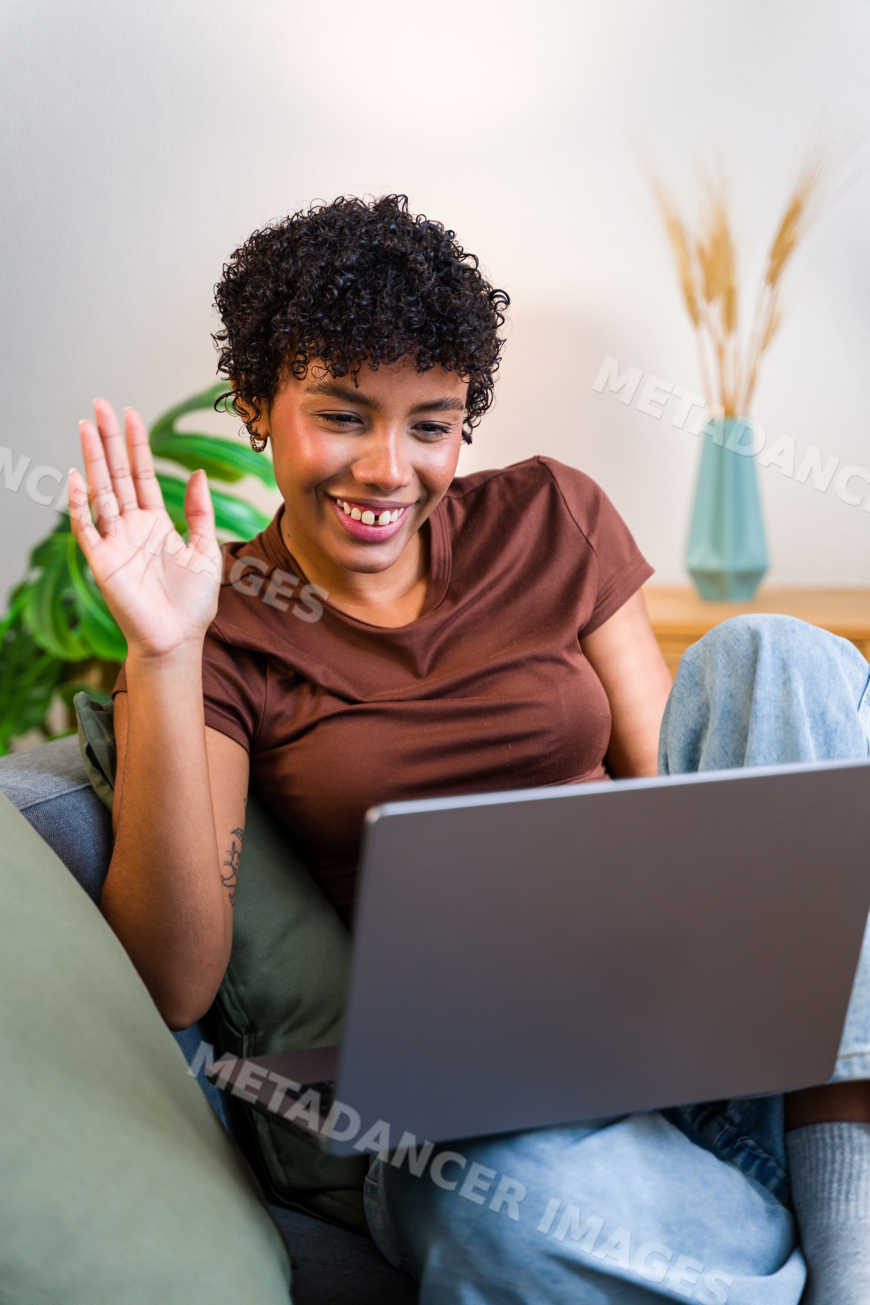 African American woman using laptop and waving during video call