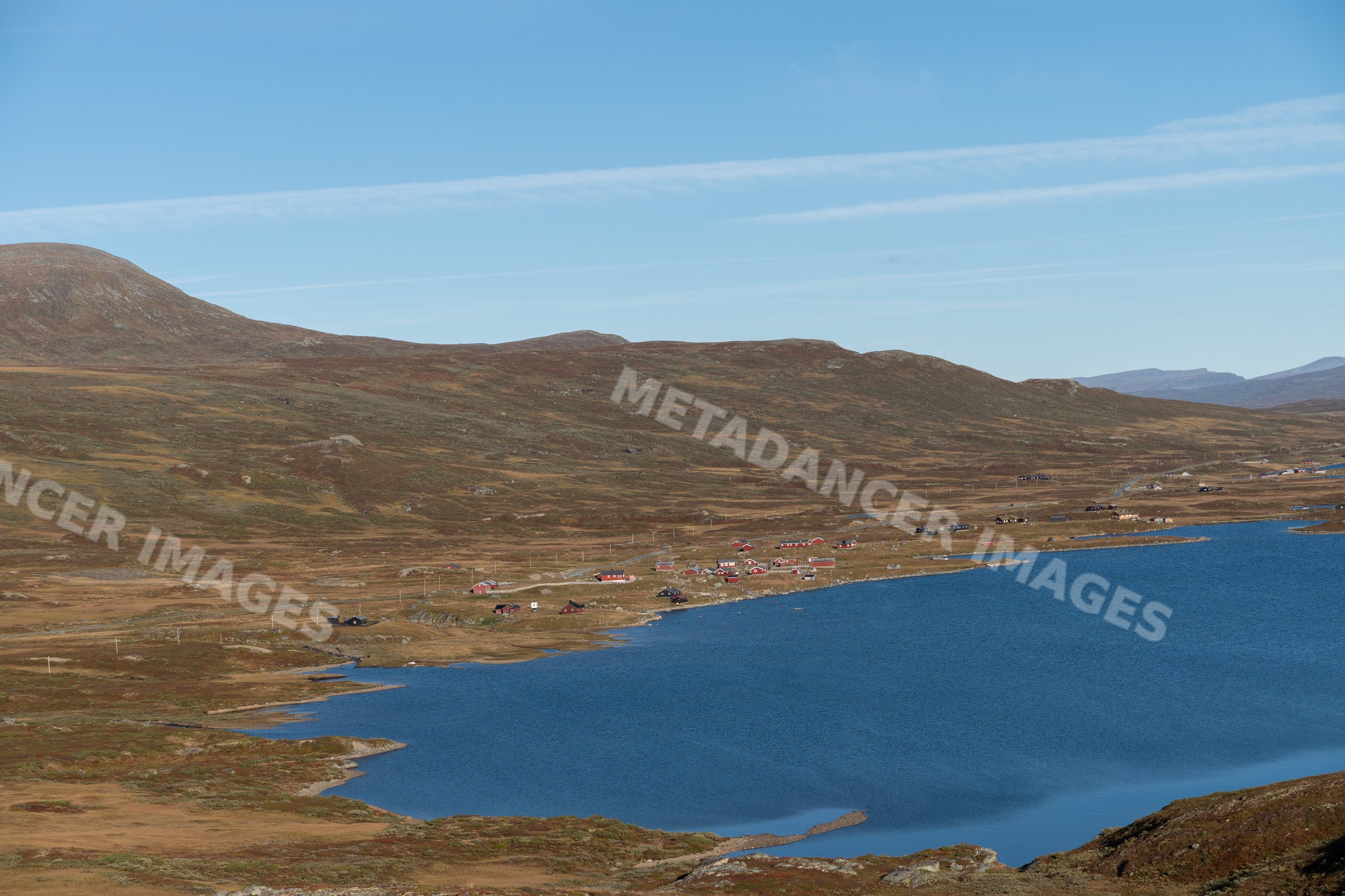 Scenic lake and rural houses surrounded by hills