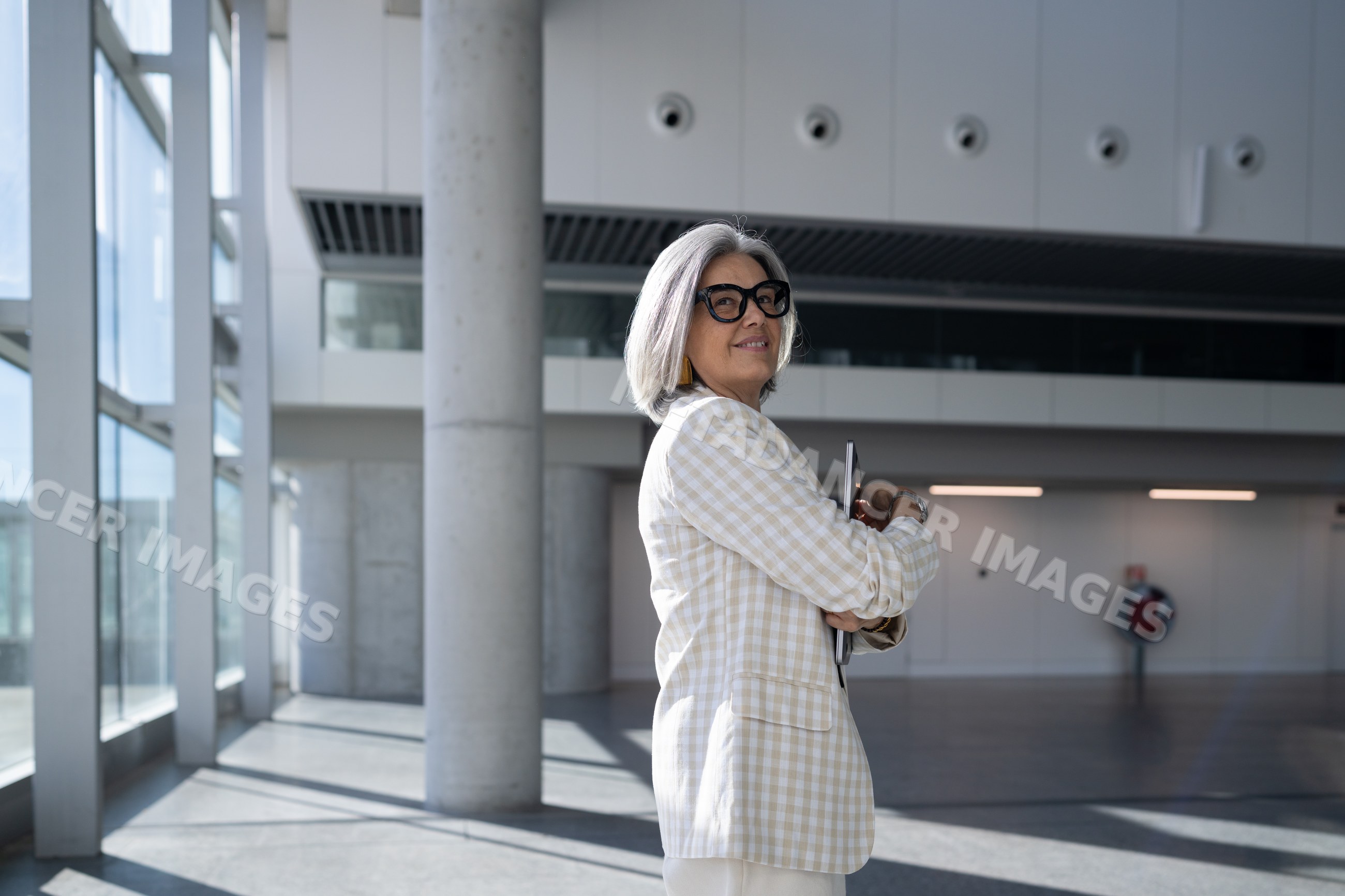Businesswoman holding tablet inside modern building with natural light