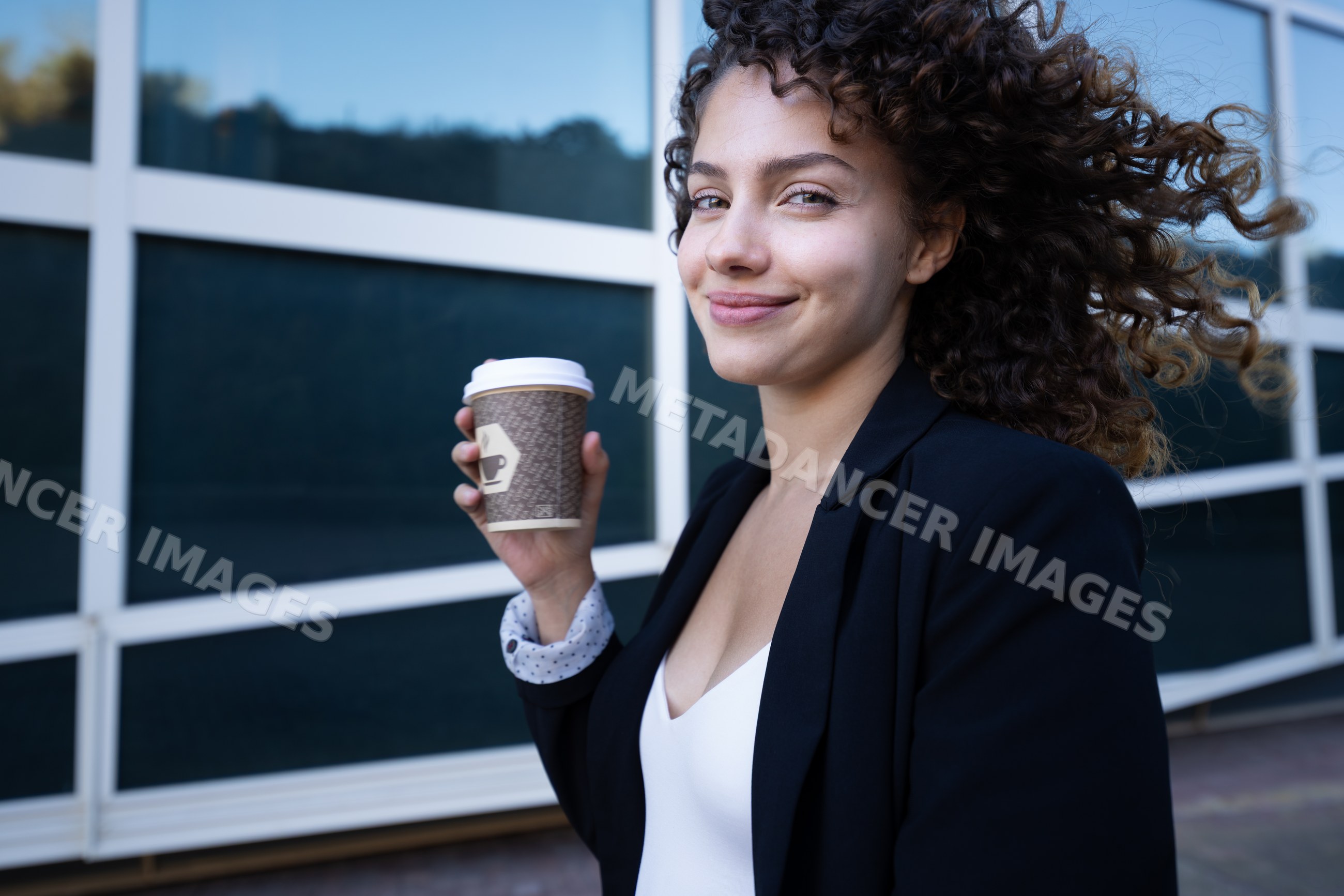 White woman holding coffee cup outdoors