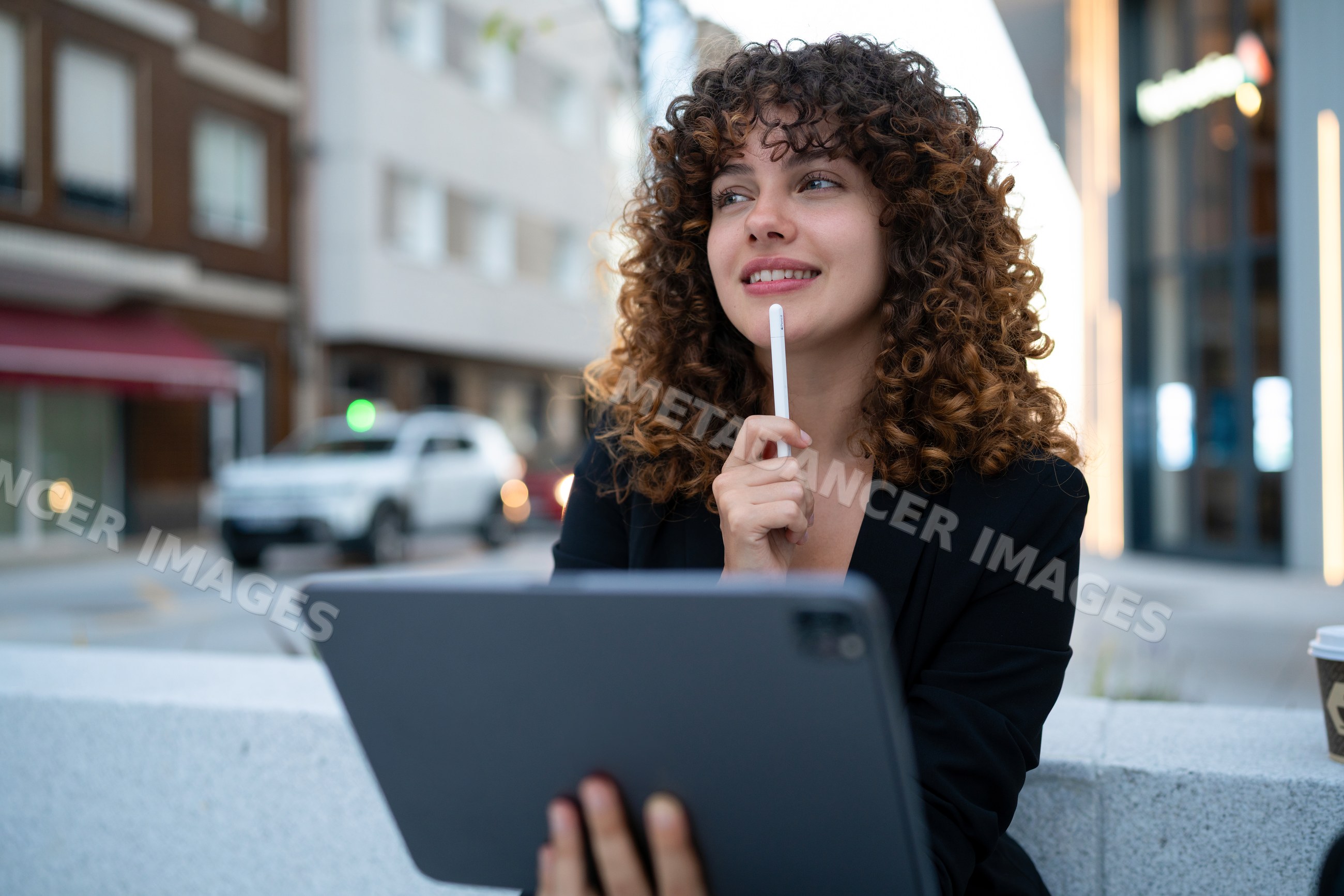Young white woman holding tablet and stylus in urban Madrid setting