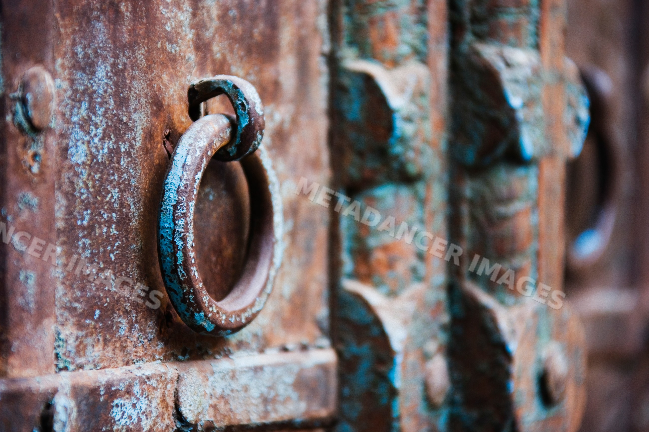 Rusty metal ring door handle on old weathered door