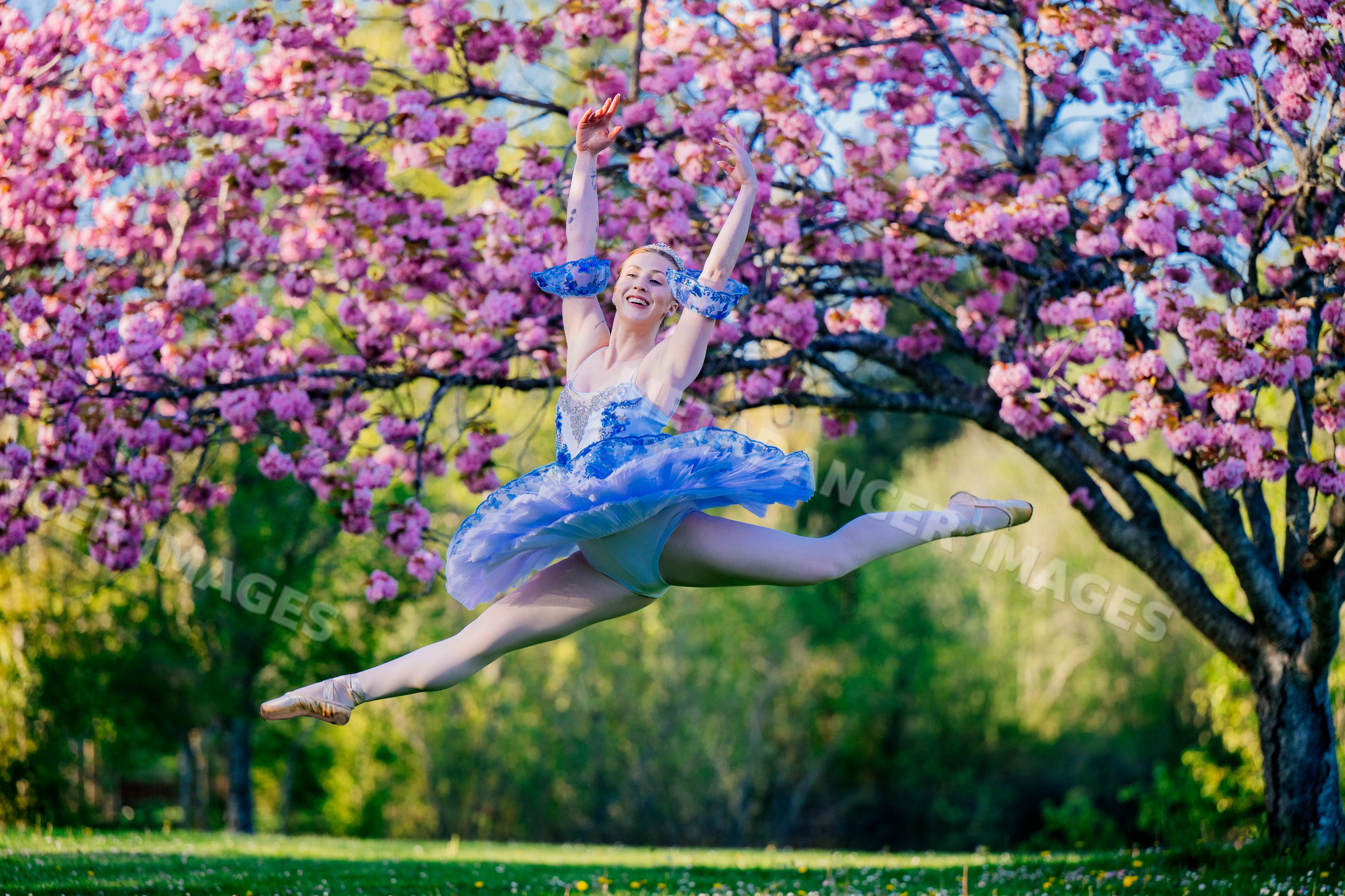 A ballerina leaps gracefully outdoors