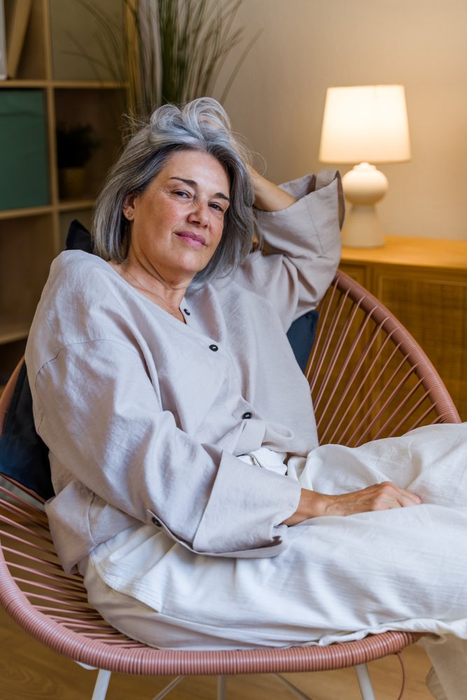 White woman relaxing in modern chair at home interior