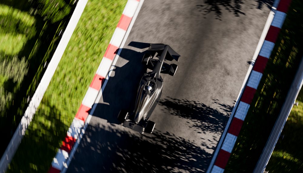 A black open-wheel race car racing on a curved asphalt track section