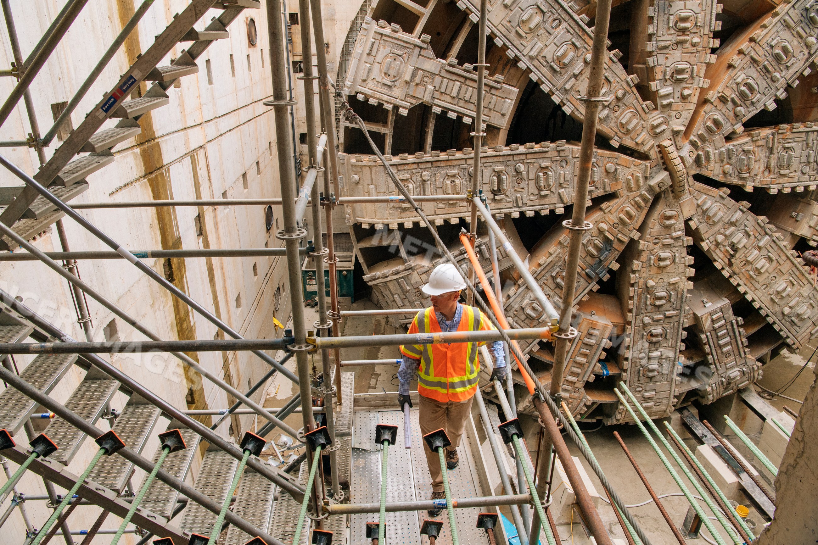 Two construction white workers inspecting a tunnel boring machine