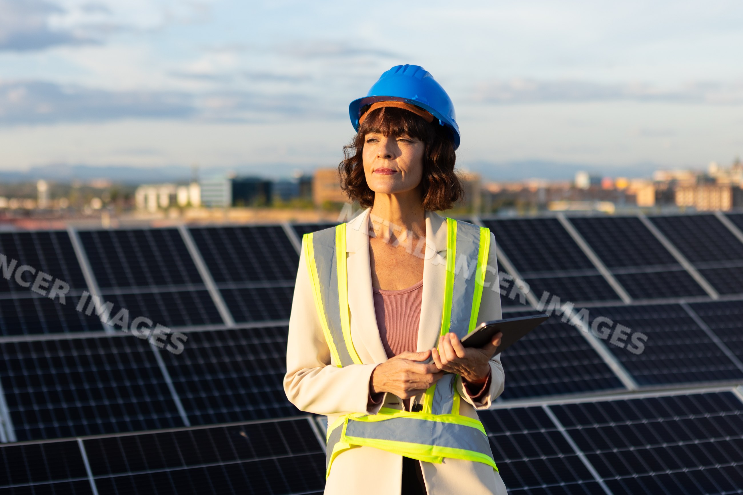 White woman engineer inspecting solar panels at solar farm in Madrid