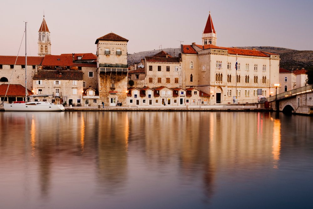 Town of trogir at dawn reflecting in harbor water