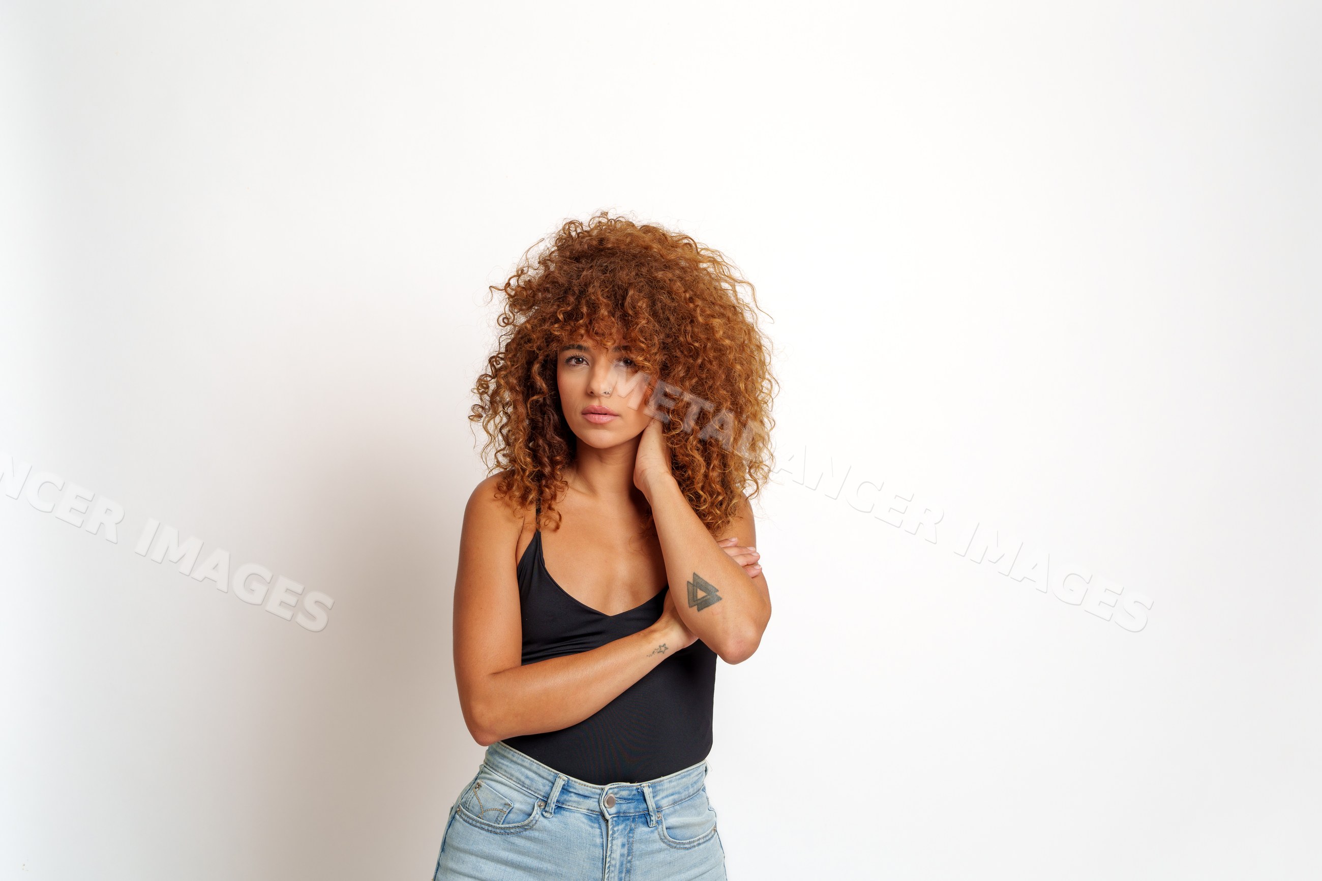Hispanic woman with curly red hair and tattoo posing, Spain