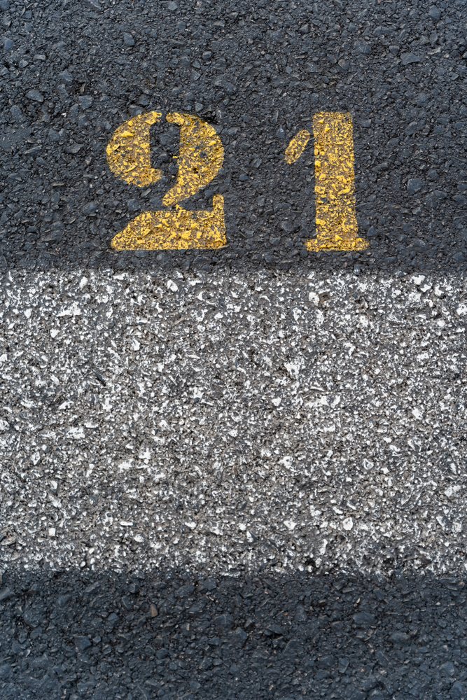 Road surface with yellow number 21 painted on asphalt