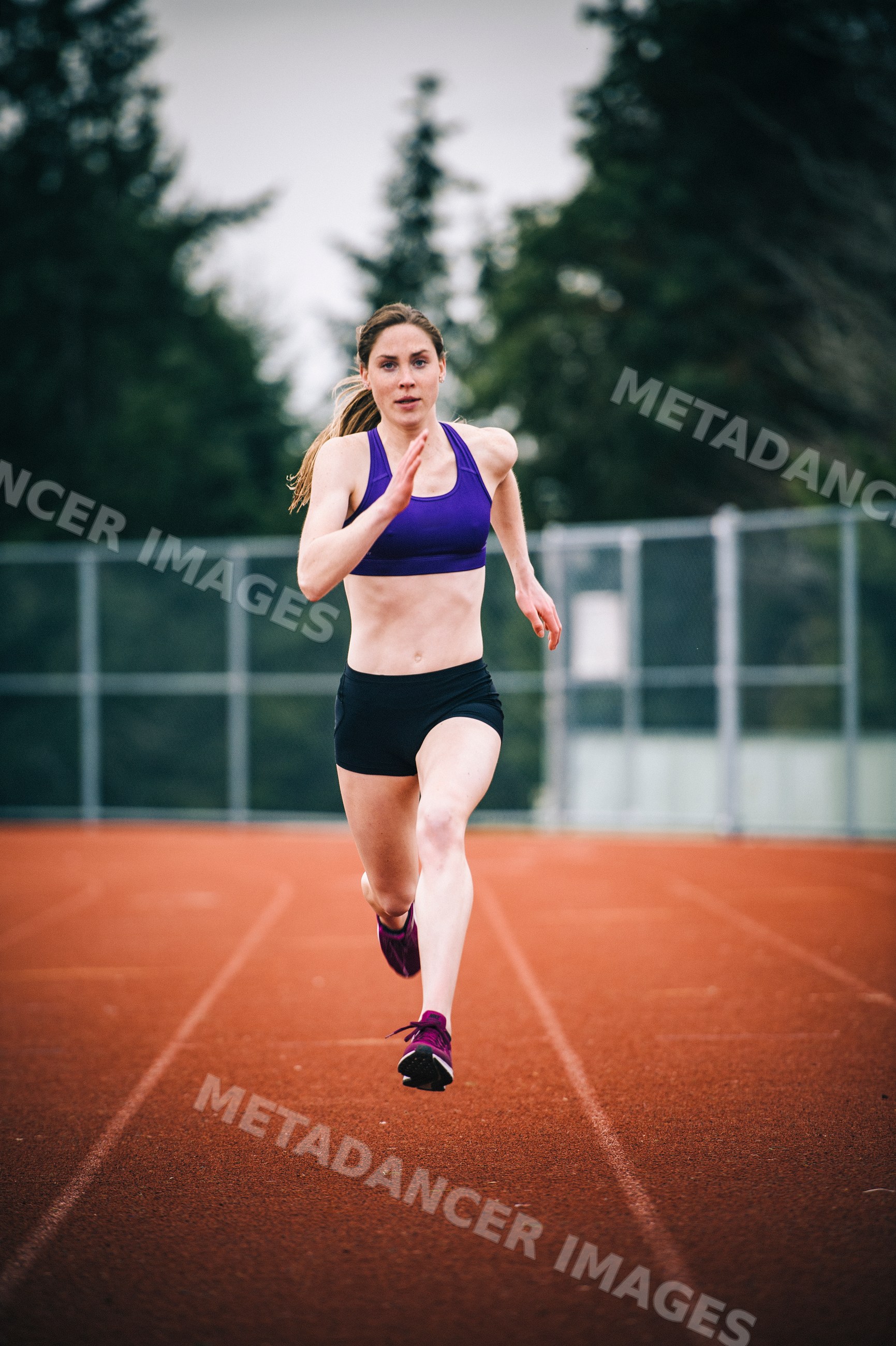 White woman sprinting on running track during outdoor training